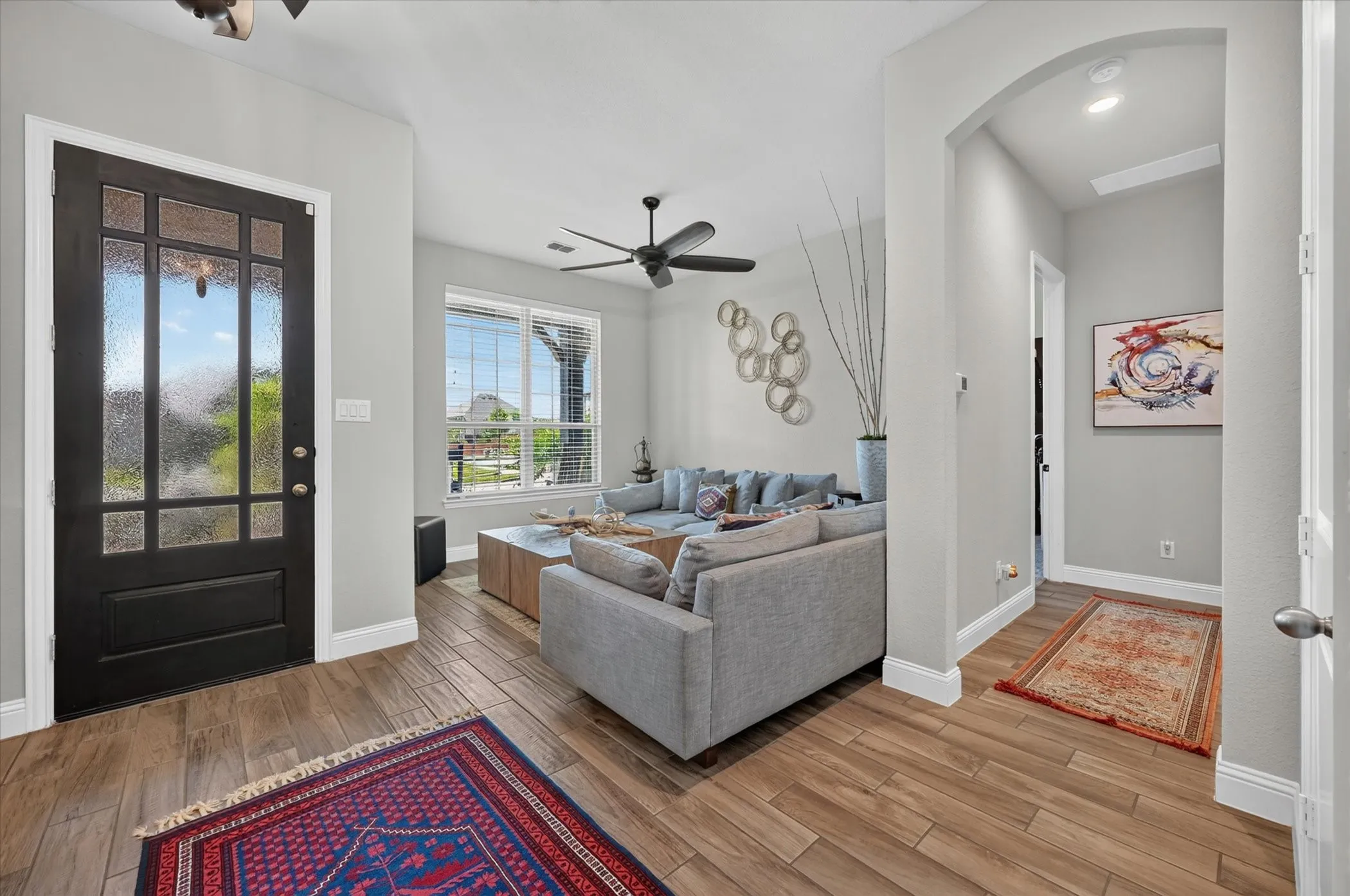 Entryway featuring a dark wood door with privacy glass, wood-finish flooring, and white baseboards