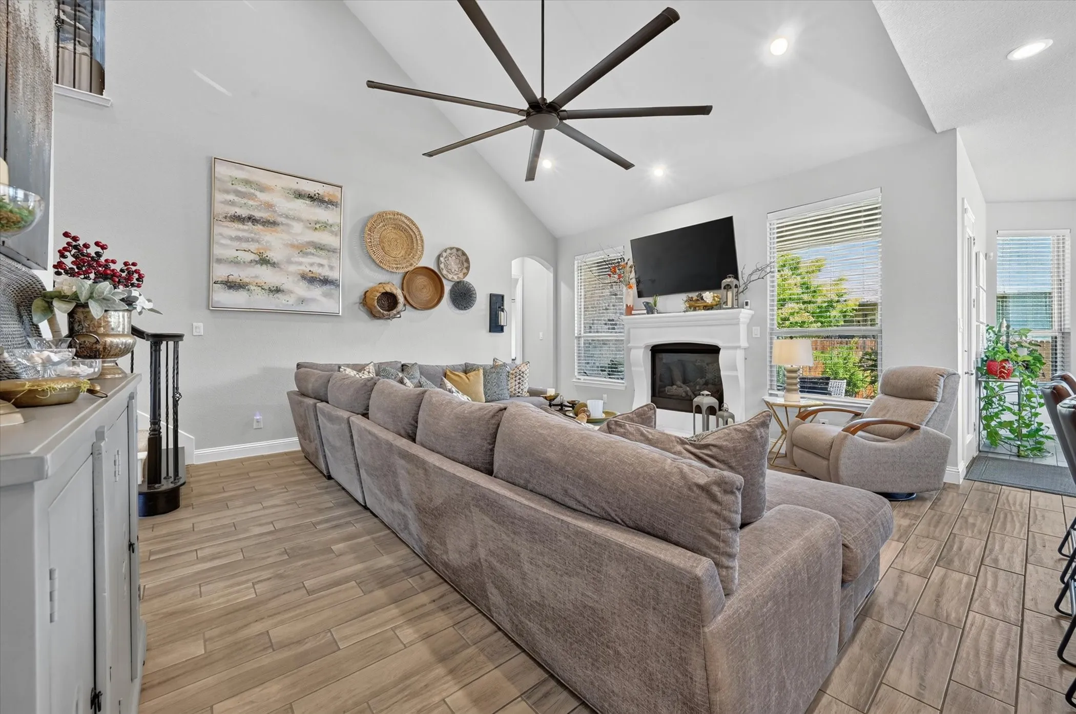 Spacious living area featuring vaulted ceilings, recessed lighting, and wood-finish flooring