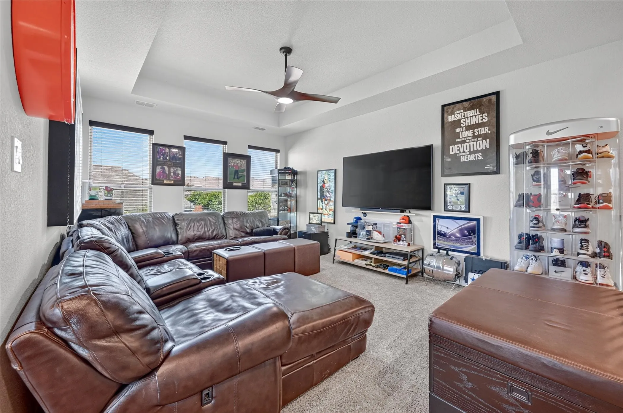 Living space featuring a tray ceiling, recessed lighting, and a contemporary ceiling fan