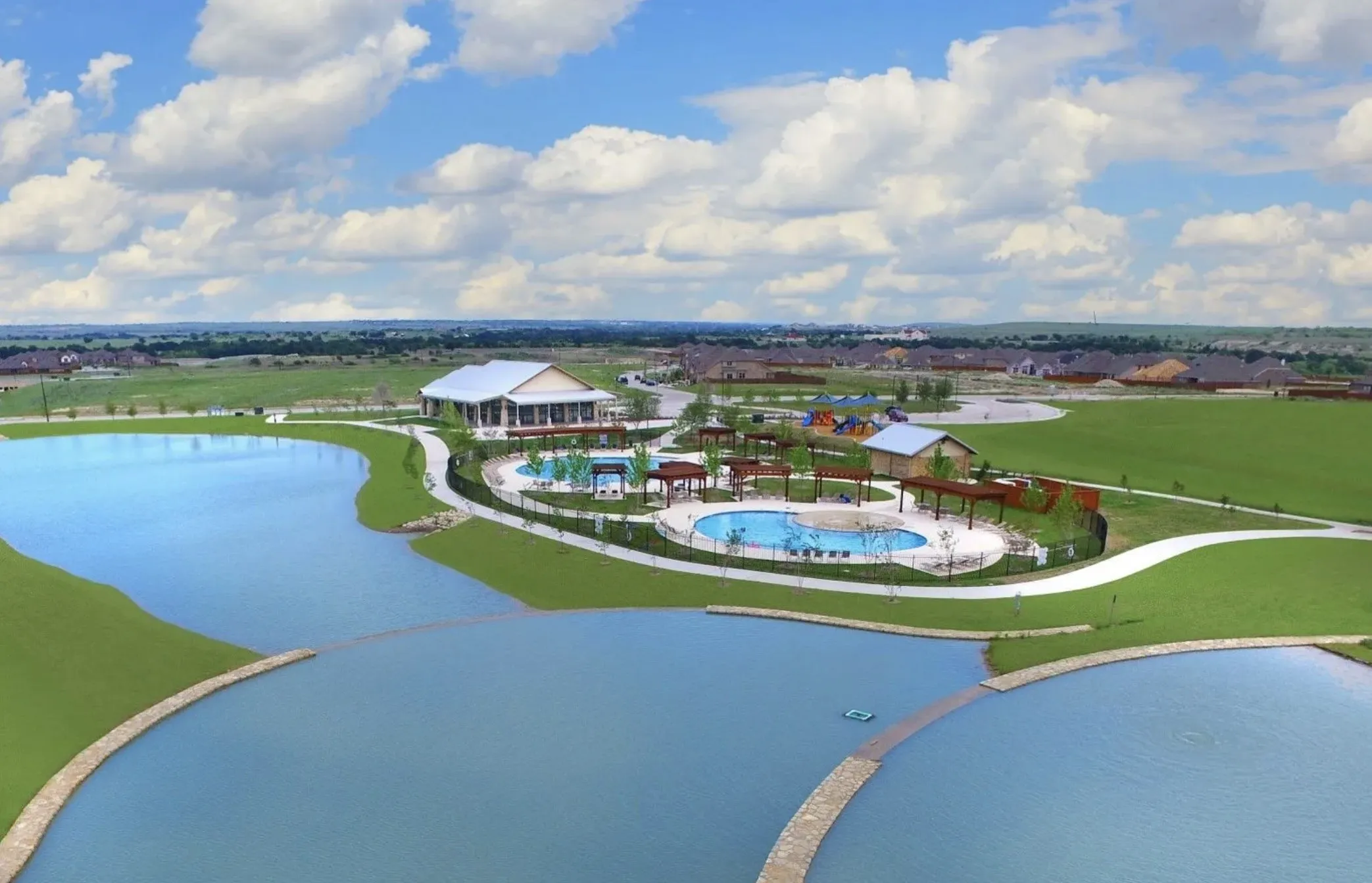 Expansive community amenity center featuring a large swimming pool, covered pergolas, and a separate playground area