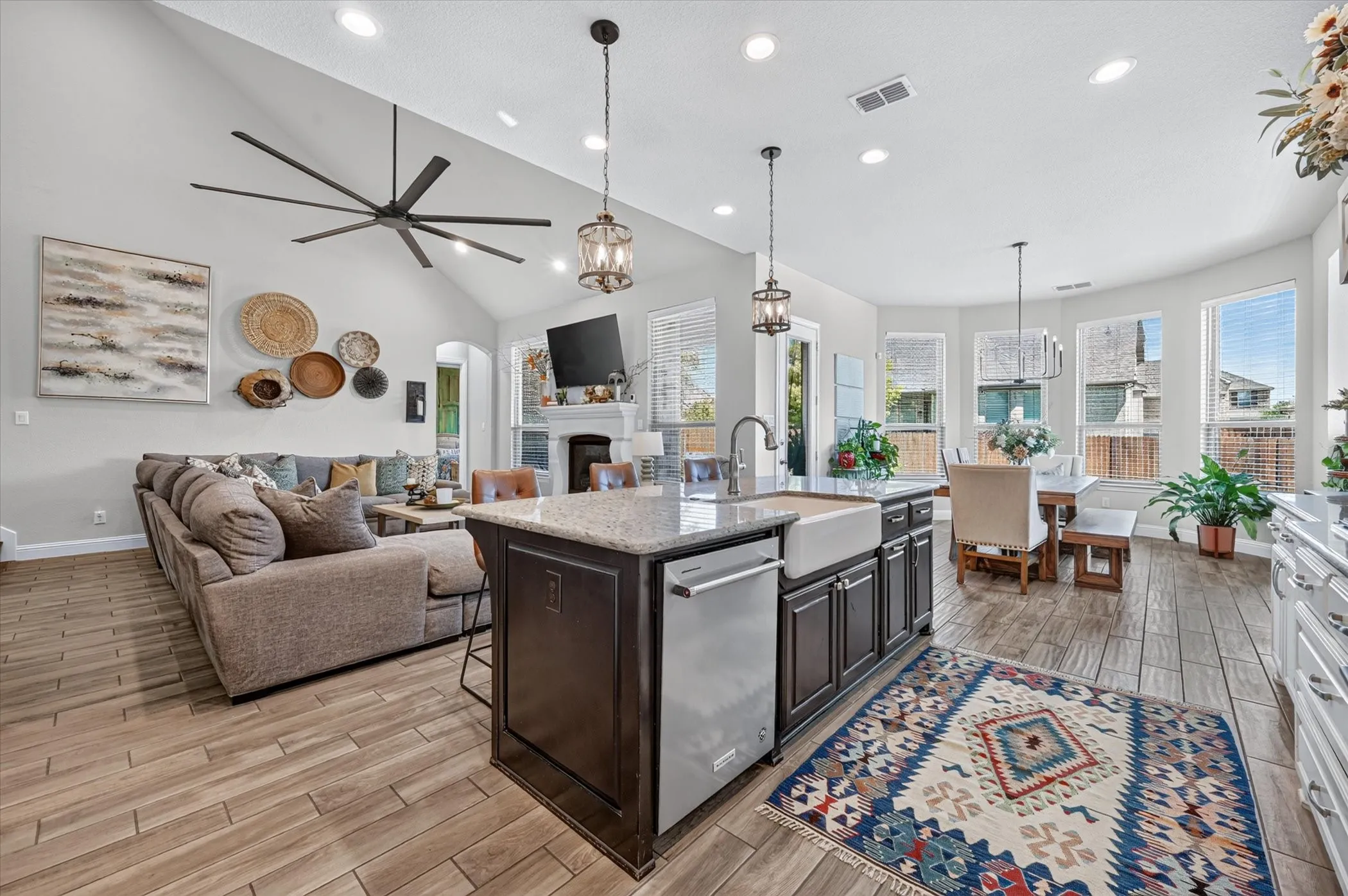 Open-concept living space with vaulted ceilings, wood-finish flooring, and recessed lighting