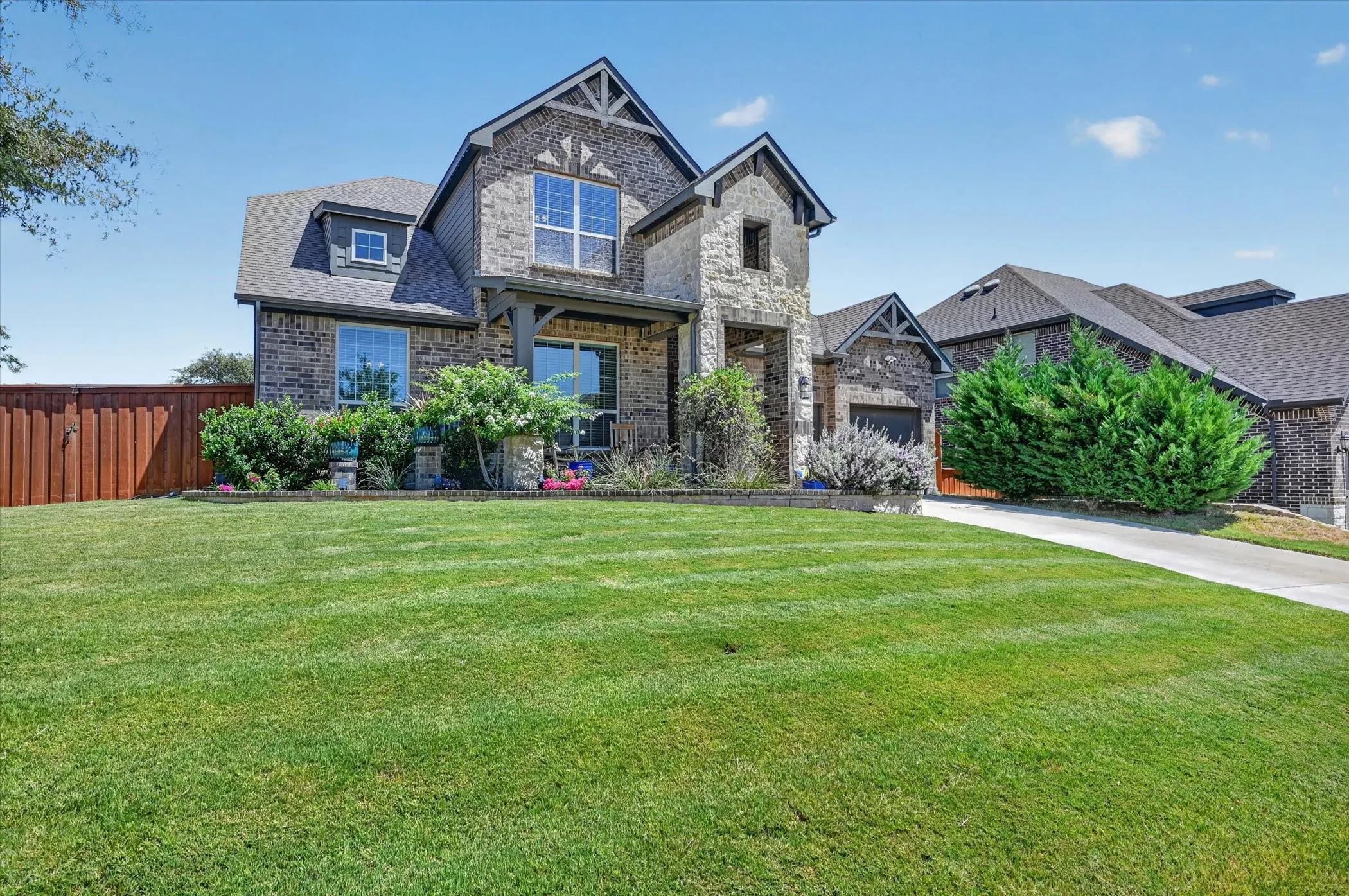 Stately brick and stone exterior with prominent gables and a covered front porch