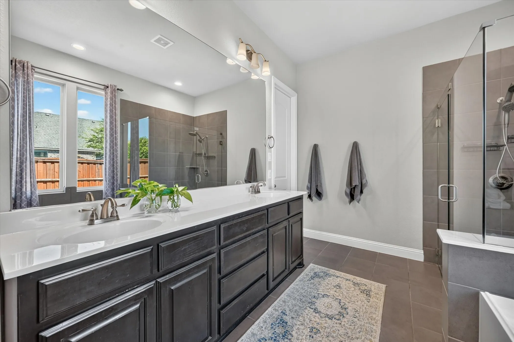 Double vanity with white countertop and dark wood-finish cabinetry