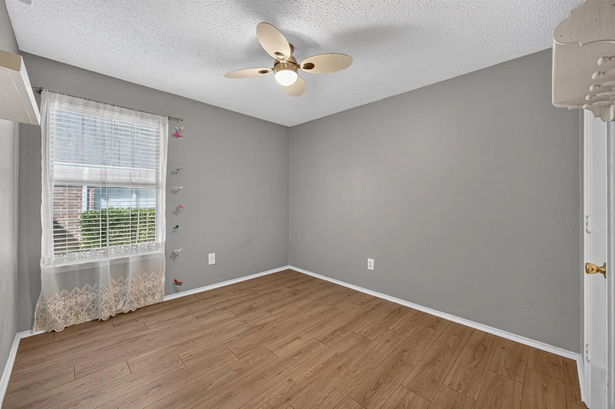 Room featuring wood-finish flooring, neutral gray walls, and a white ceiling