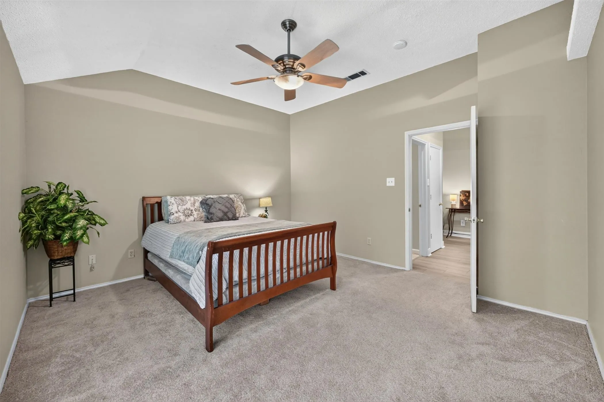 Spacious room with vaulted ceiling and a ceiling fan with integrated lighting