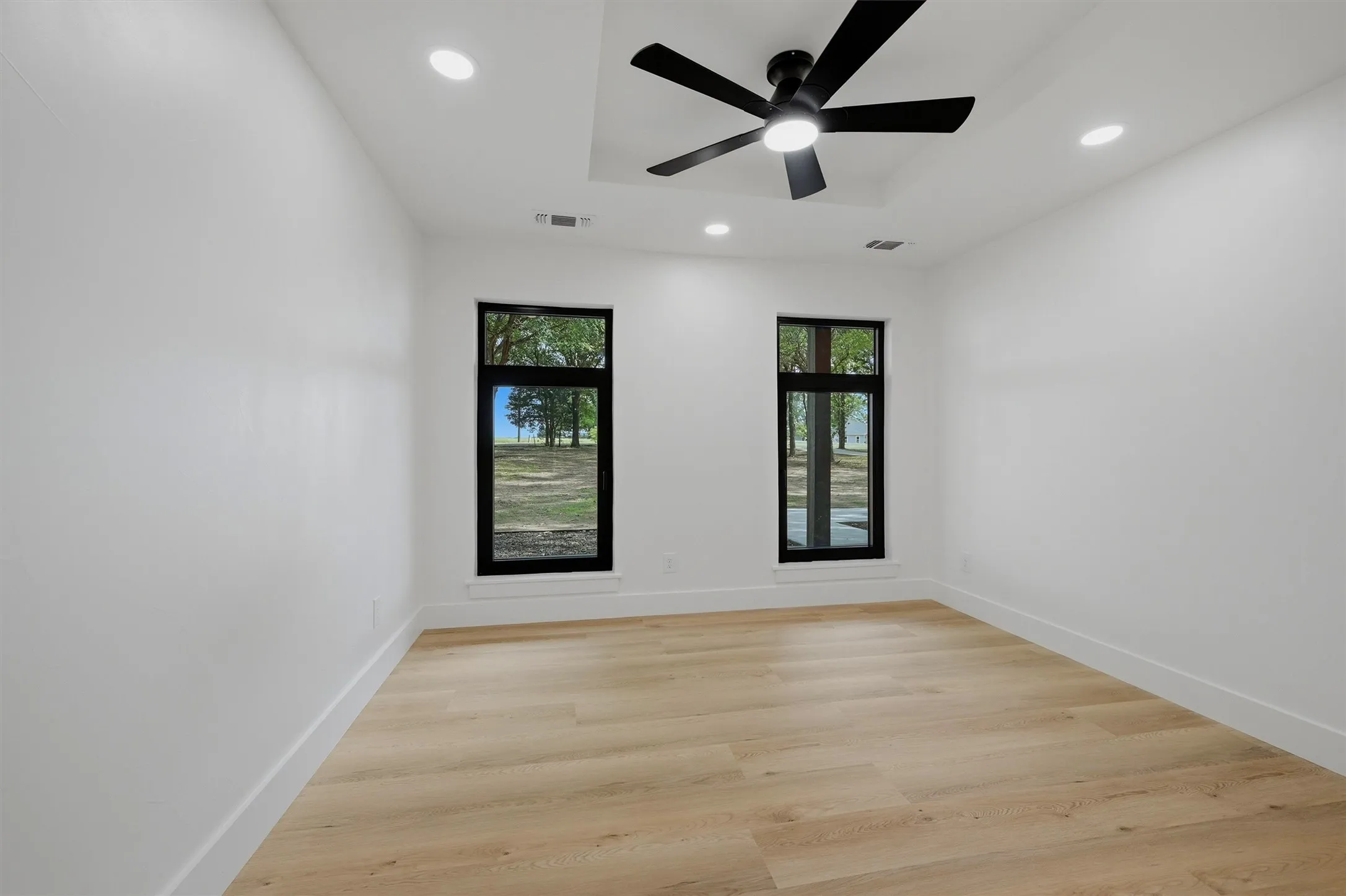 Bright interior space featuring light wood-finish flooring and crisp white walls