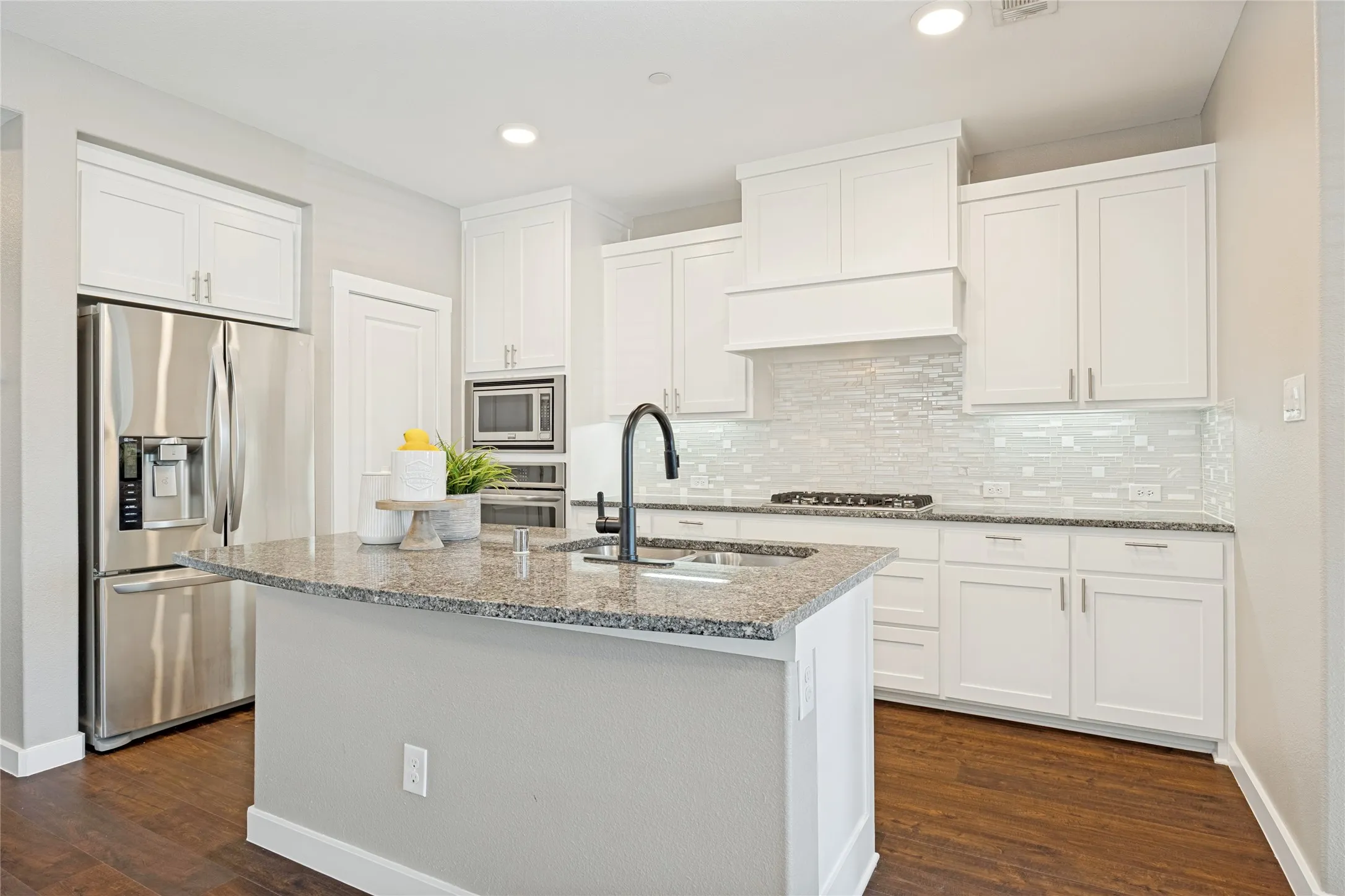 Bright and light kitchen with granite counters and undermounted sink. Centered around a kitchen island, offering good workspace and flow.