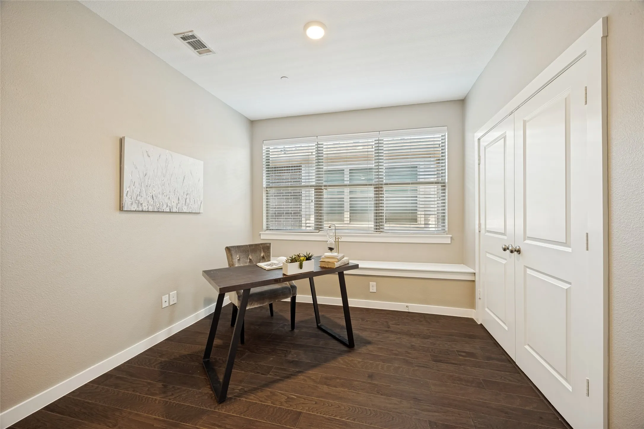 The room is light and airy with windows that include bench seating for reading or work space.