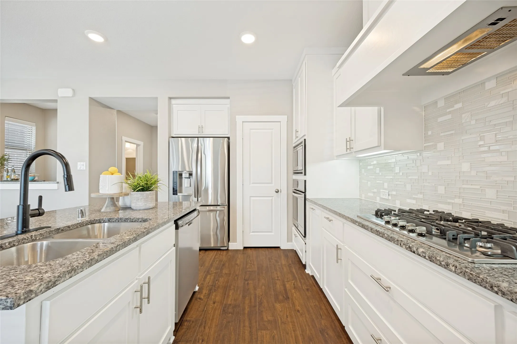 A wall mounted oven offers additional drawer storage under the gas range. Function meets beauty in this well thought kitchen.