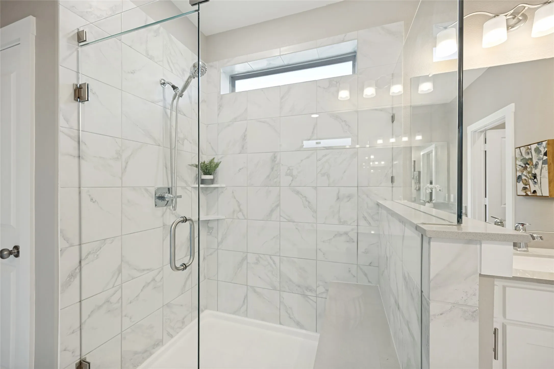 Oversized walk-in shower with gorgeous floor to ceiling tile and bench for extra relaxation. This space is yours to unwind.