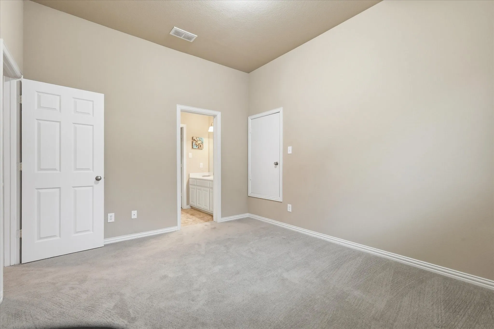 Spacious room with vaulted ceilings and light beige walls