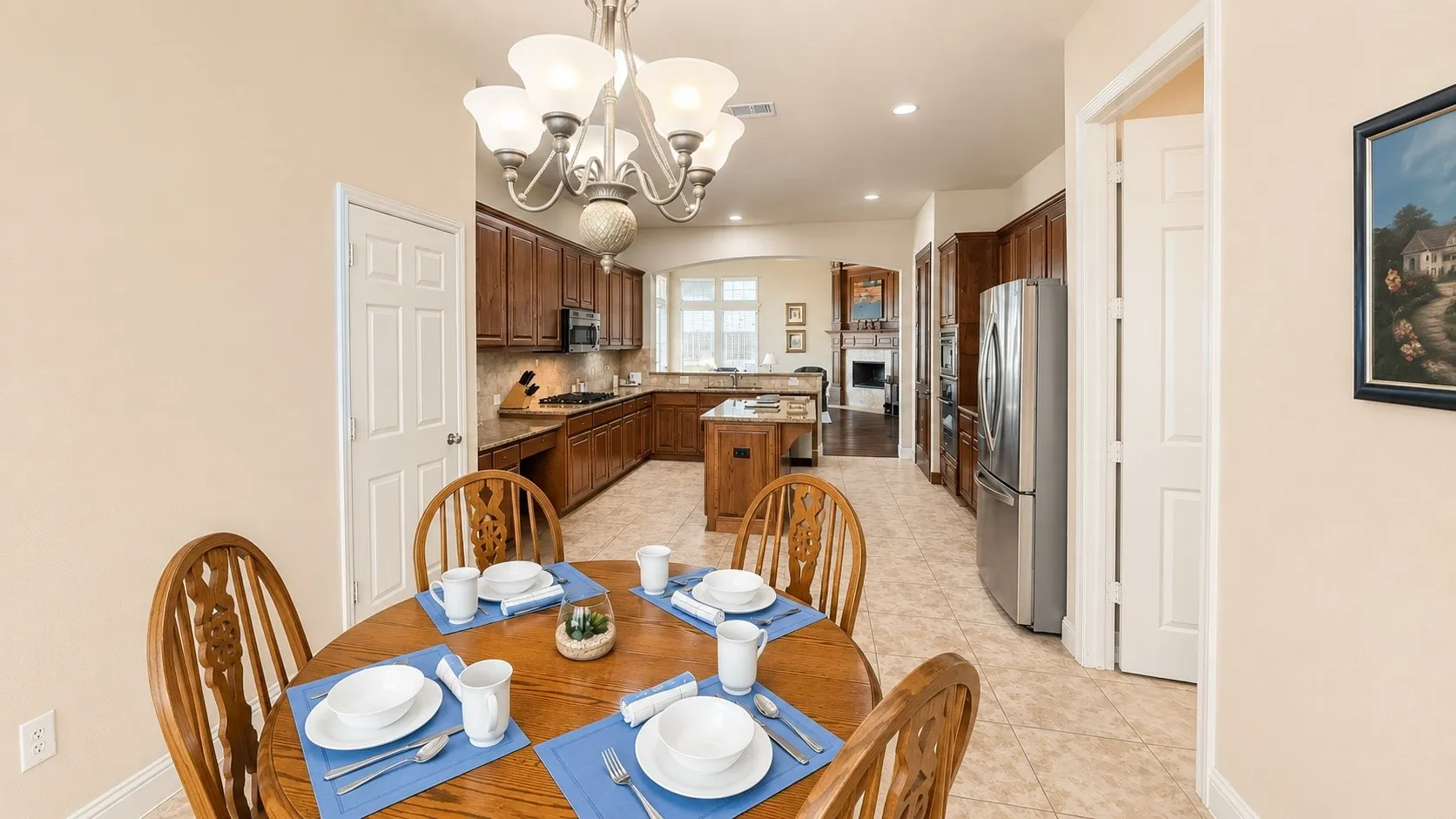 Open-concept kitchen and dining area featuring warm wood cabinetry, a central island with bar seating, and stainless steel appliances