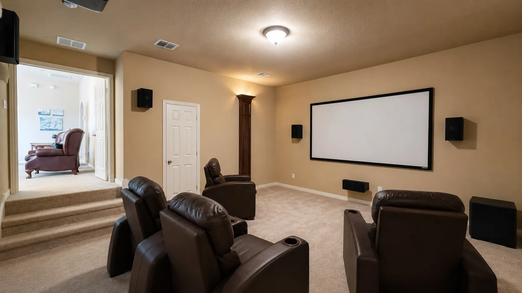 Dedicated media room featuring a large projection screen, wall-mounted speakers, and recessed lighting
