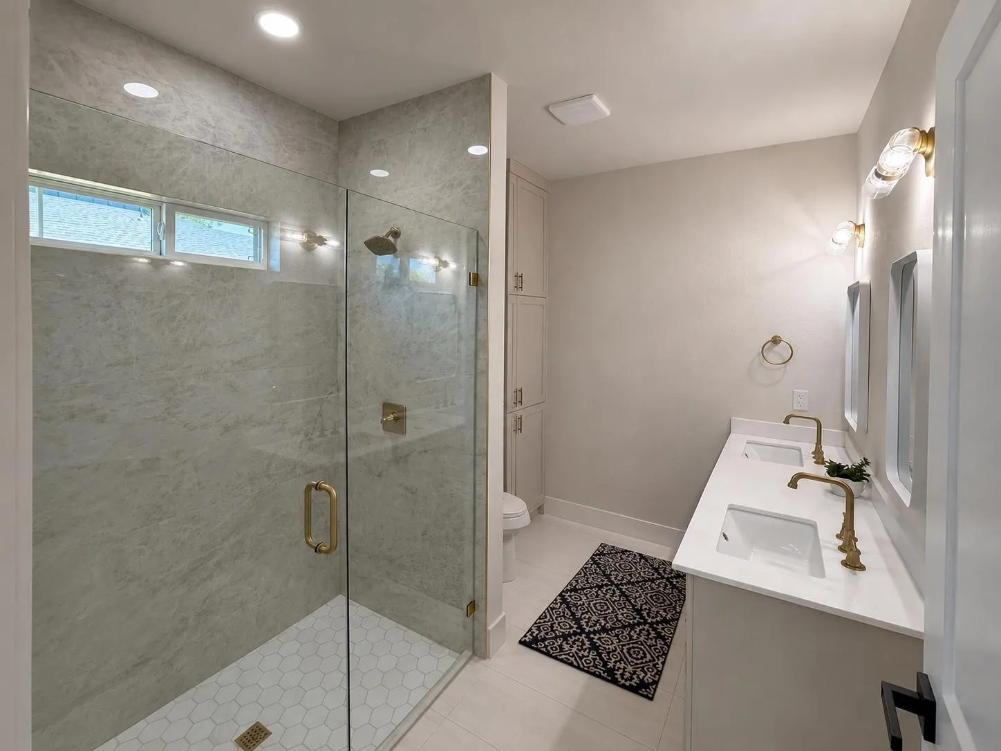 Primary bathroom featuring a glass-enclosed shower with full-height tile surround and hexagon mosaic floor