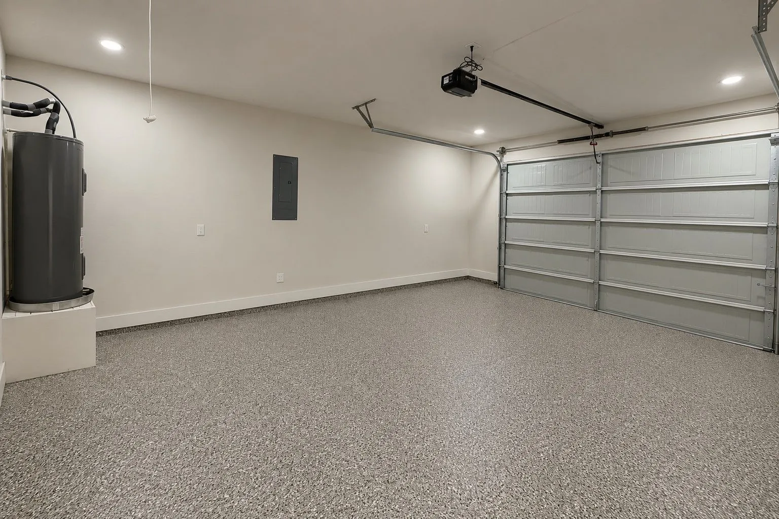 Spacious garage with an epoxy-coated floor, recessed lighting, and a neutral color palette