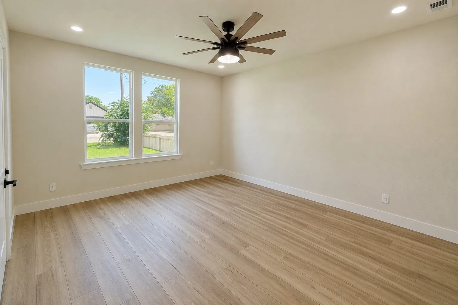 Spacious room featuring light wood-finish flooring, recessed lighting, and a modern ceiling fan