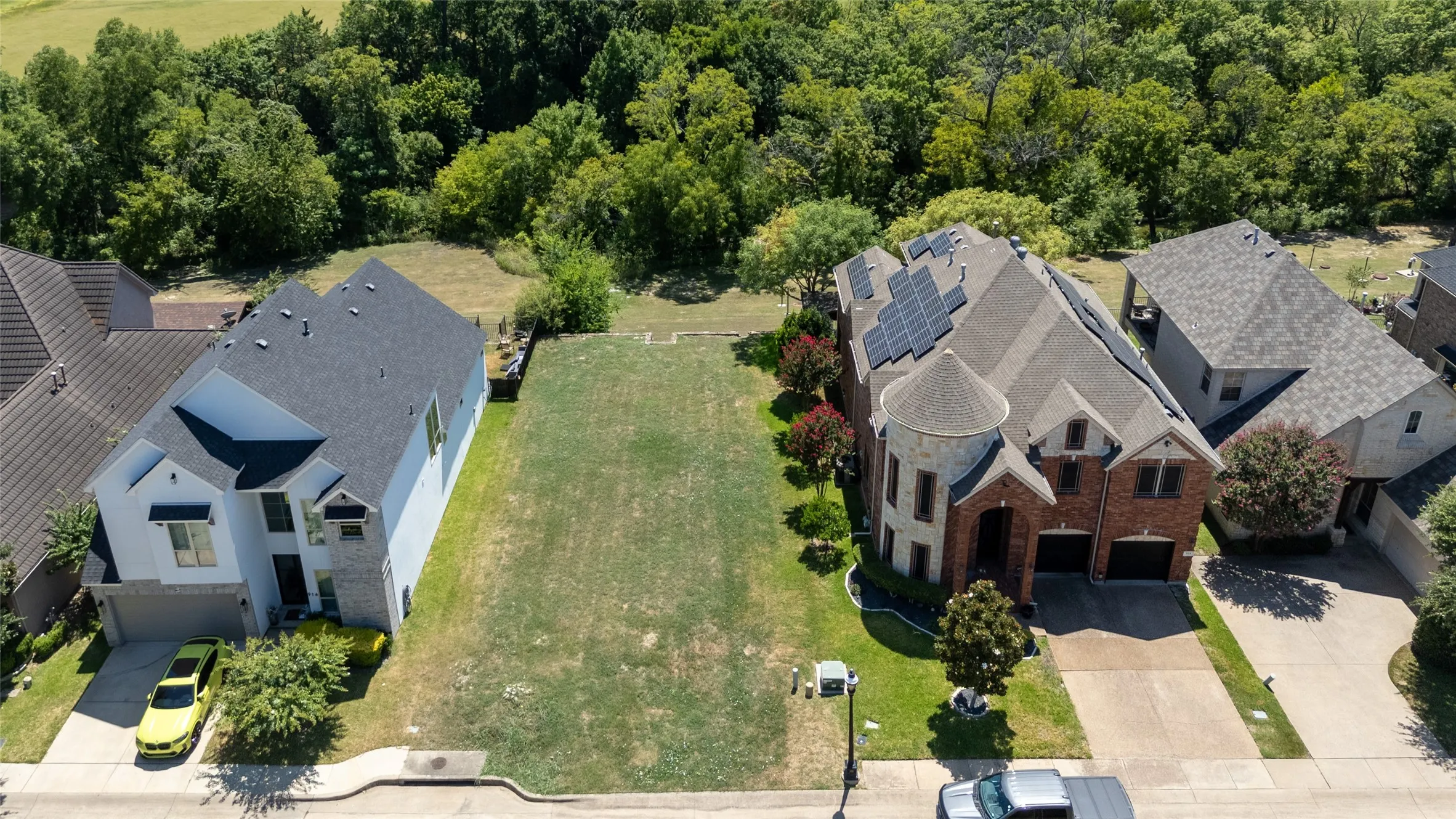 Expansive level land parcel featuring a grass surface and mature perimeter trees