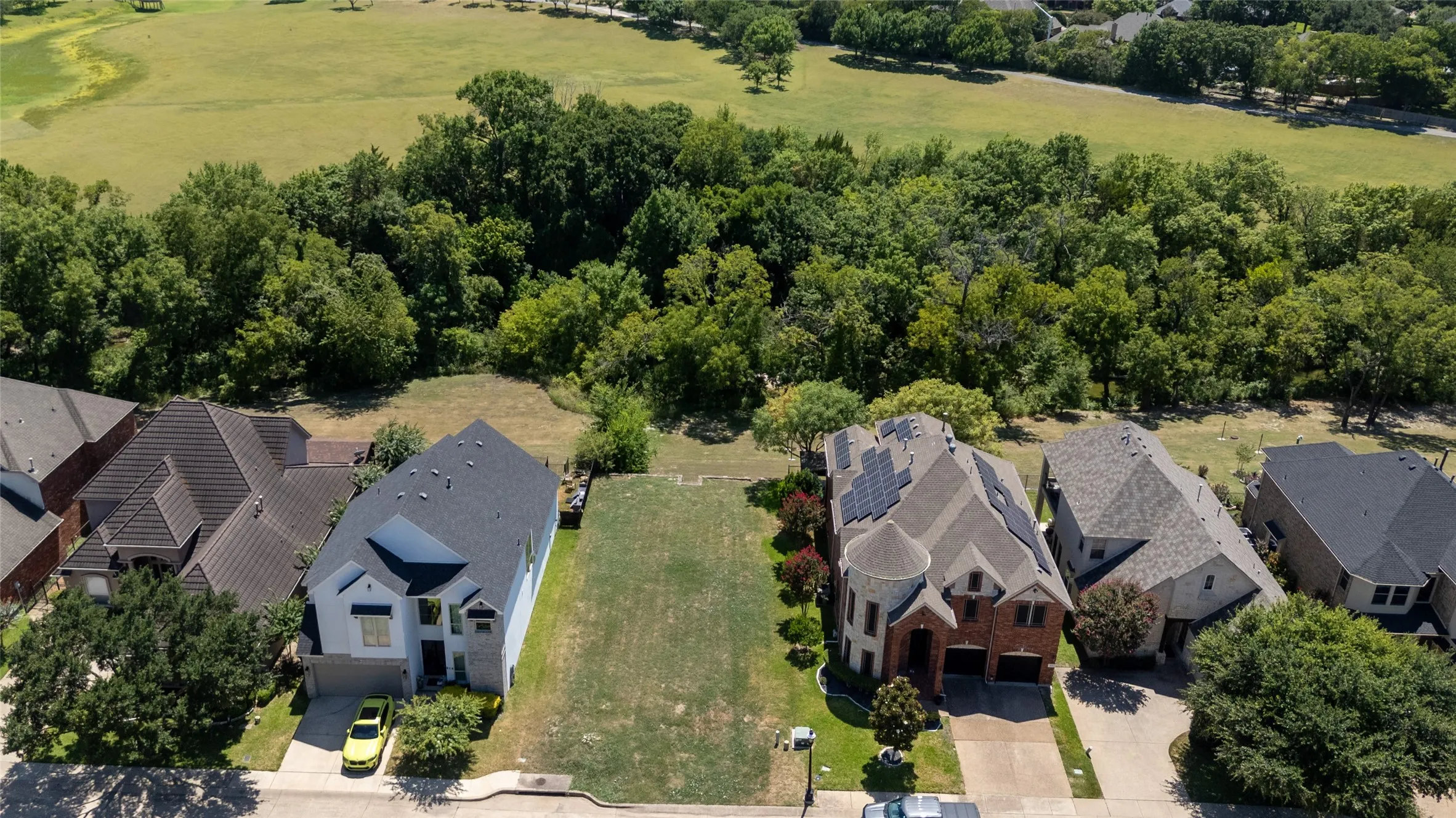 Expansive cleared lot bordered by mature trees, offering a significant building opportunity