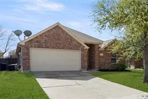 Brick facade residence with an attached two-car garage, concrete driveway, and front lawn landscaping