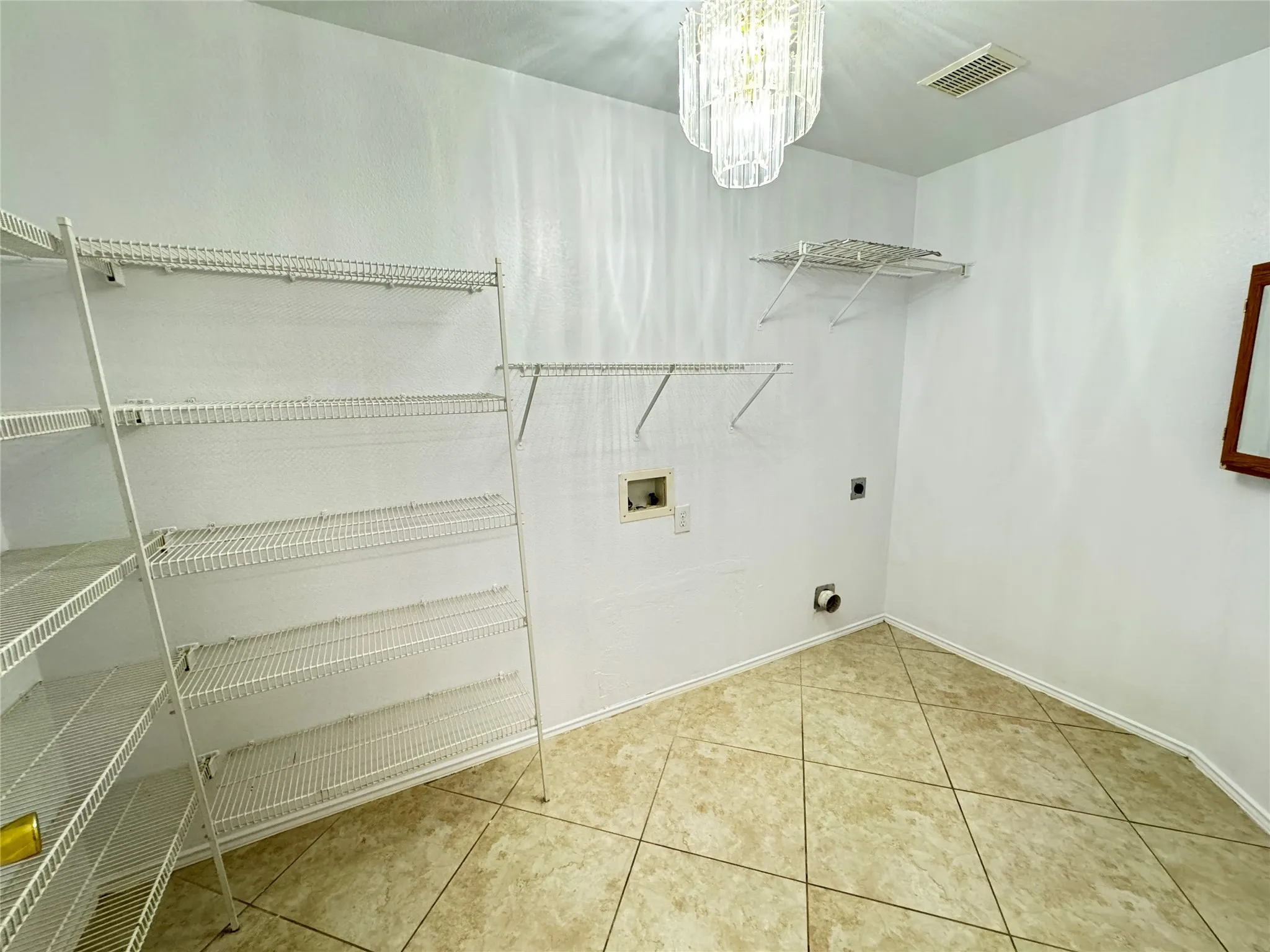 Washroom featuring electric dryer hookup, tile flooring, a chandelier, and hookup for a washing machine