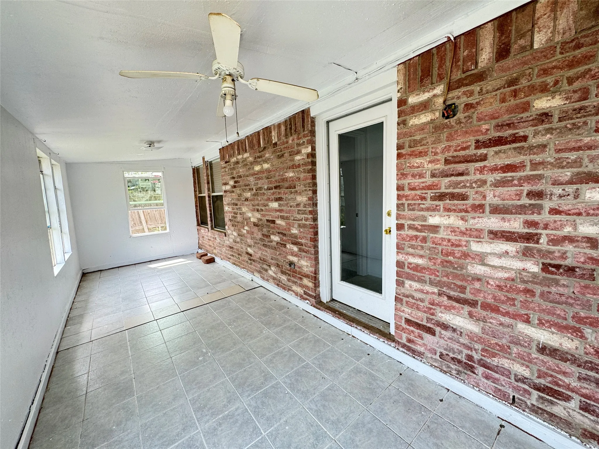 Unfurnished sunroom with ceiling fan