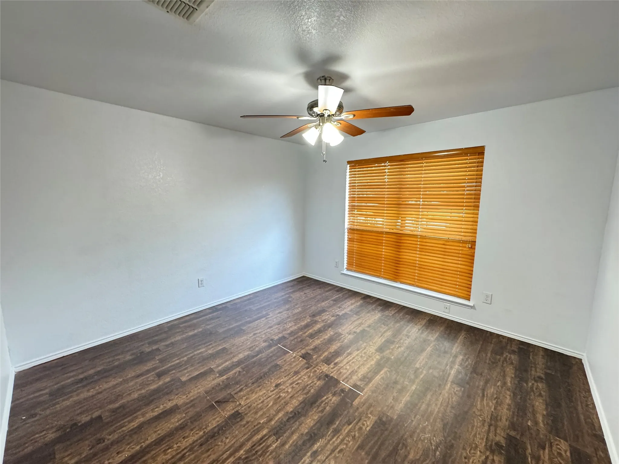 Unfurnished room featuring a textured ceiling, ceiling fan, and hardwood / wood-style floors