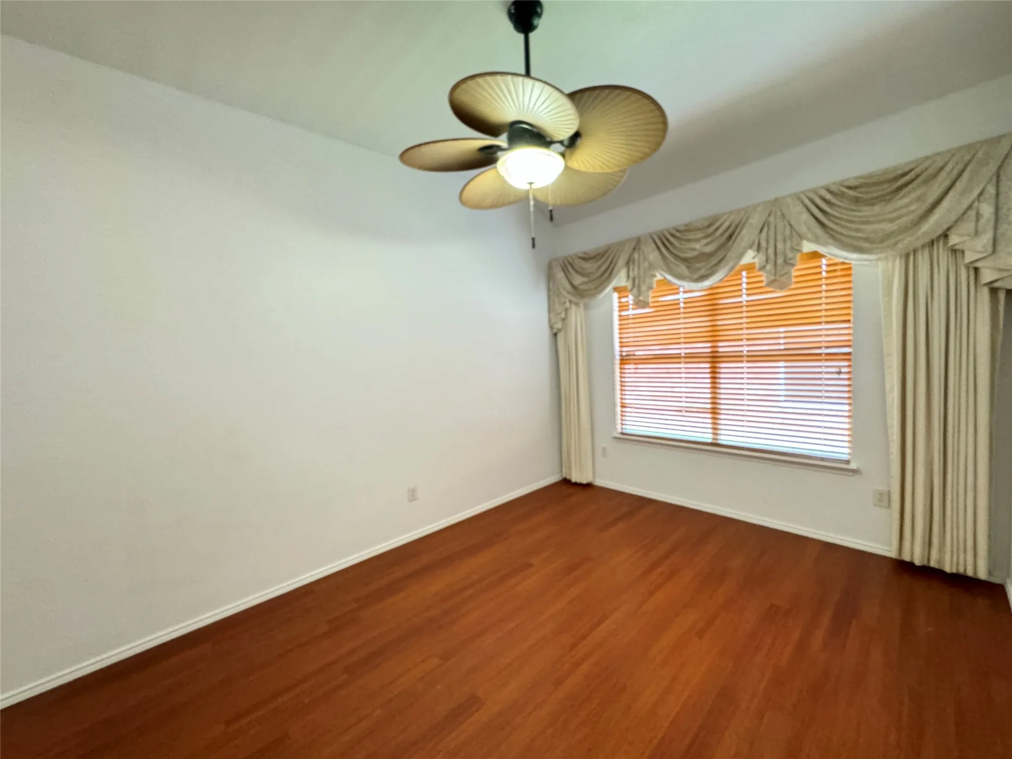 Unfurnished room with dark hardwood / wood-style floors and ceiling fan