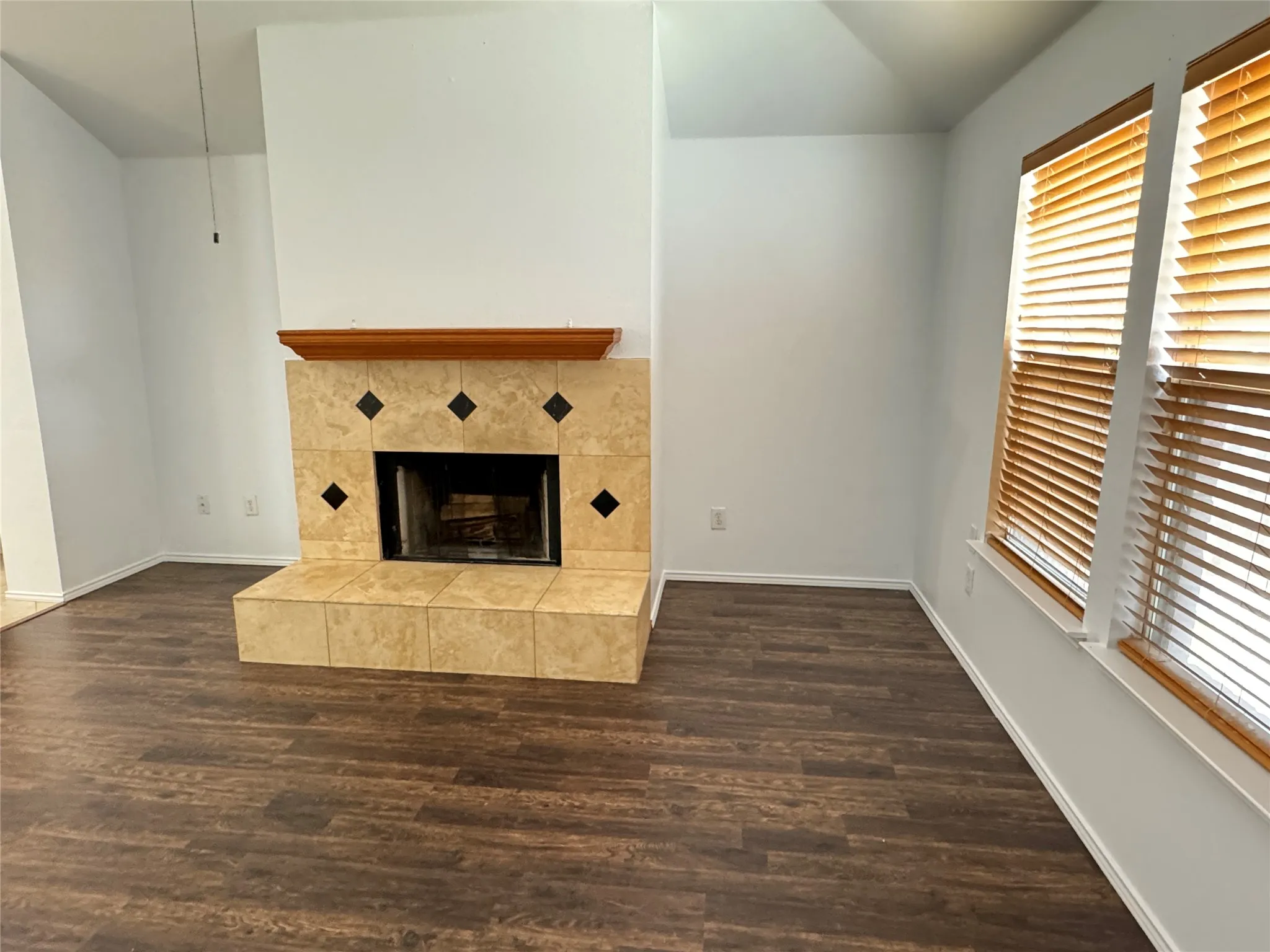 Unfurnished living room with hardwood / wood-style flooring and a tile fireplace