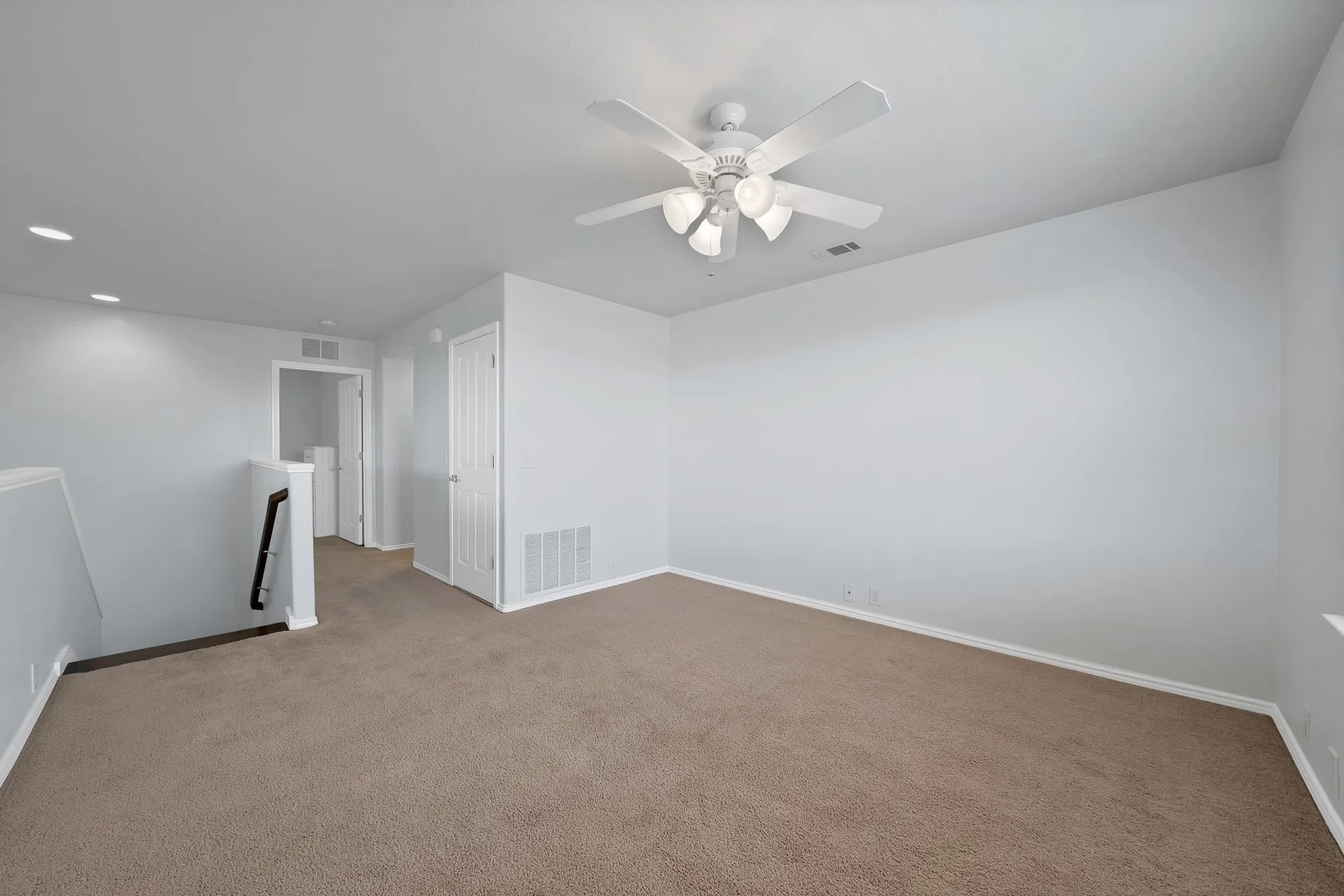 Spacious carpeted room featuring a ceiling fan with integrated lighting, recessed lighting, and crisp white trimwork