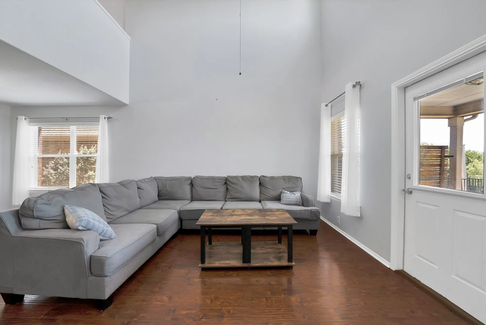 Living area featuring a high vaulted ceiling and wood-finish flooring