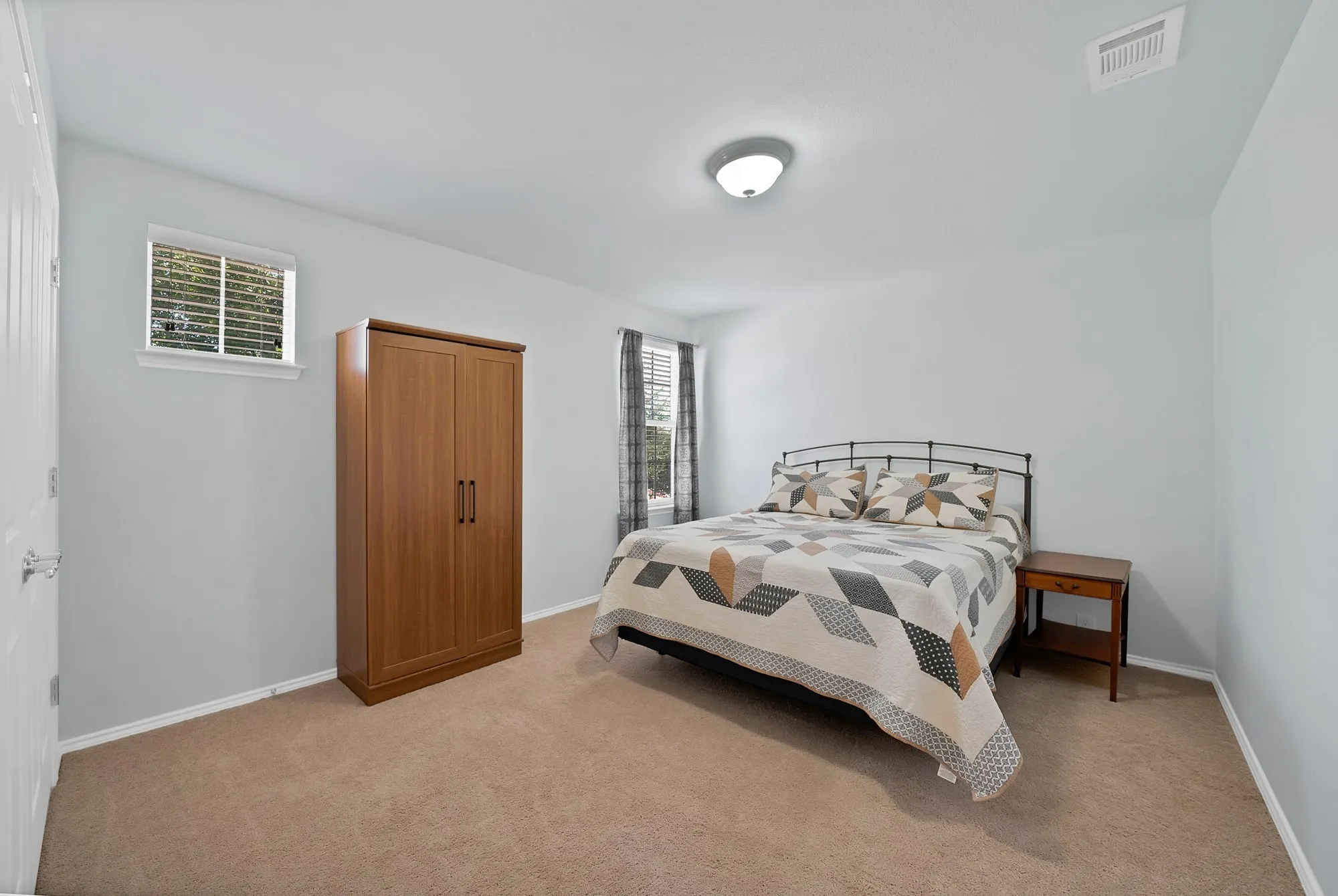 Carpeted room featuring light gray walls, a window with blinds, and an overhead flush-mount light fixture
