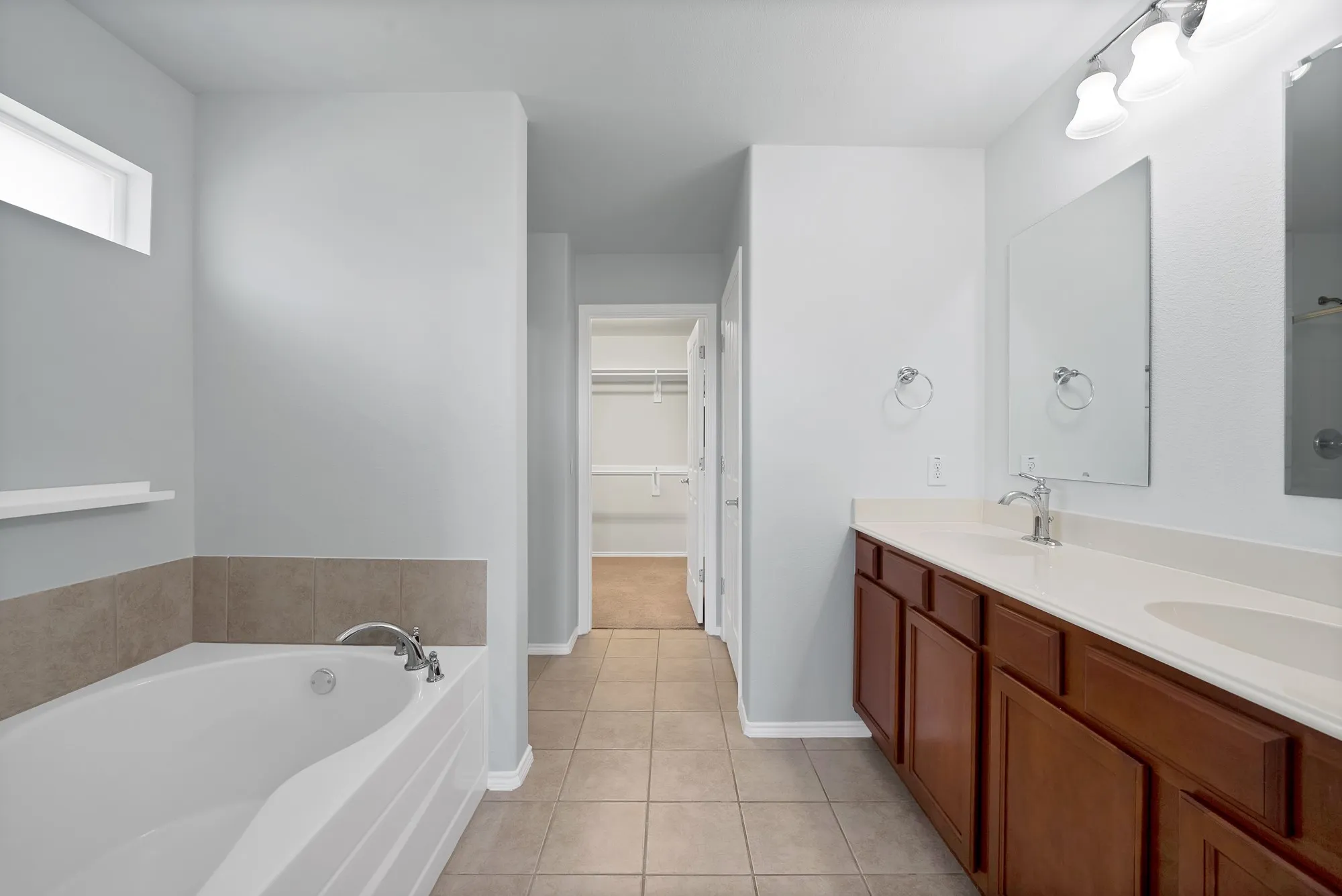 Bathroom featuring an integrated soaking tub, dual vanity with undermount sinks, and a separate water closet