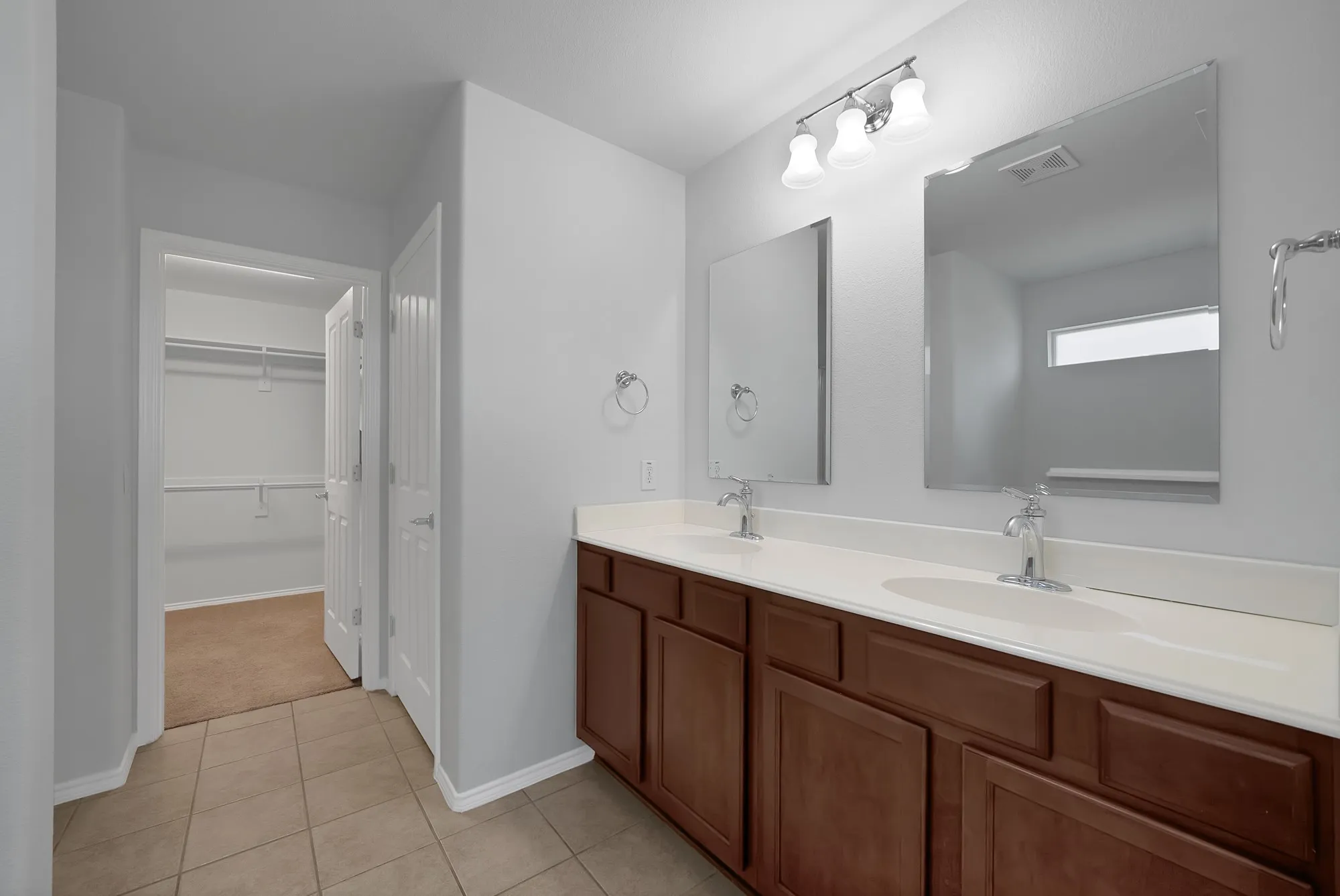 Dual vanity with white countertops, undermount sinks, and chrome fixtures