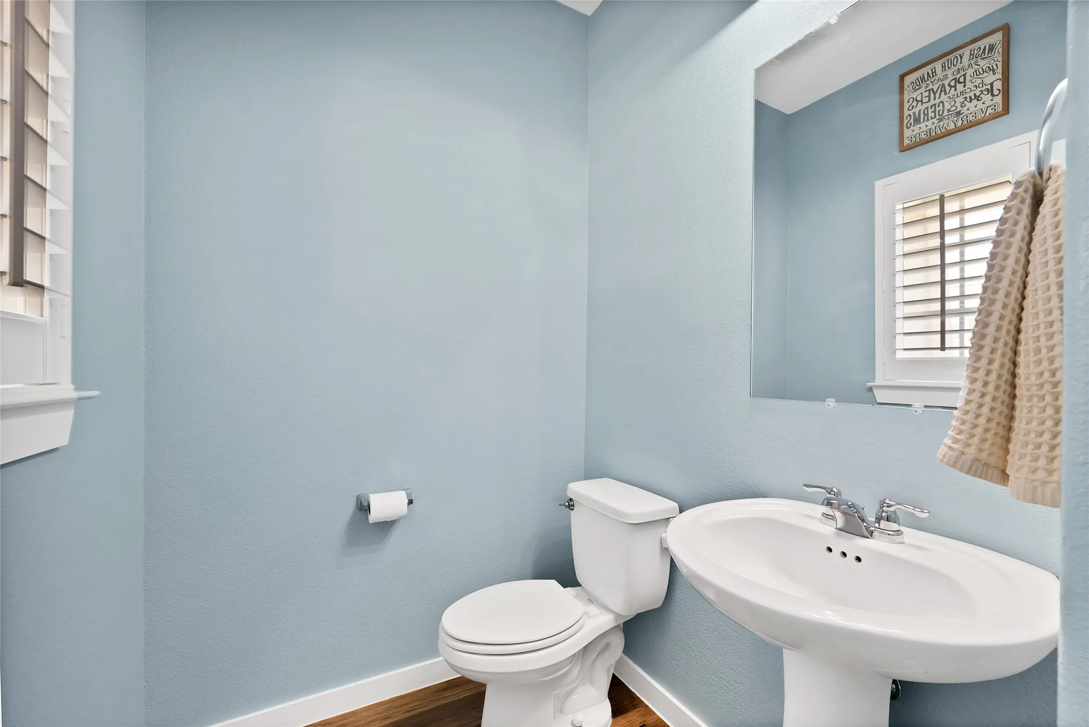 Pedestal sink with chrome faucet, complemented by a white toilet