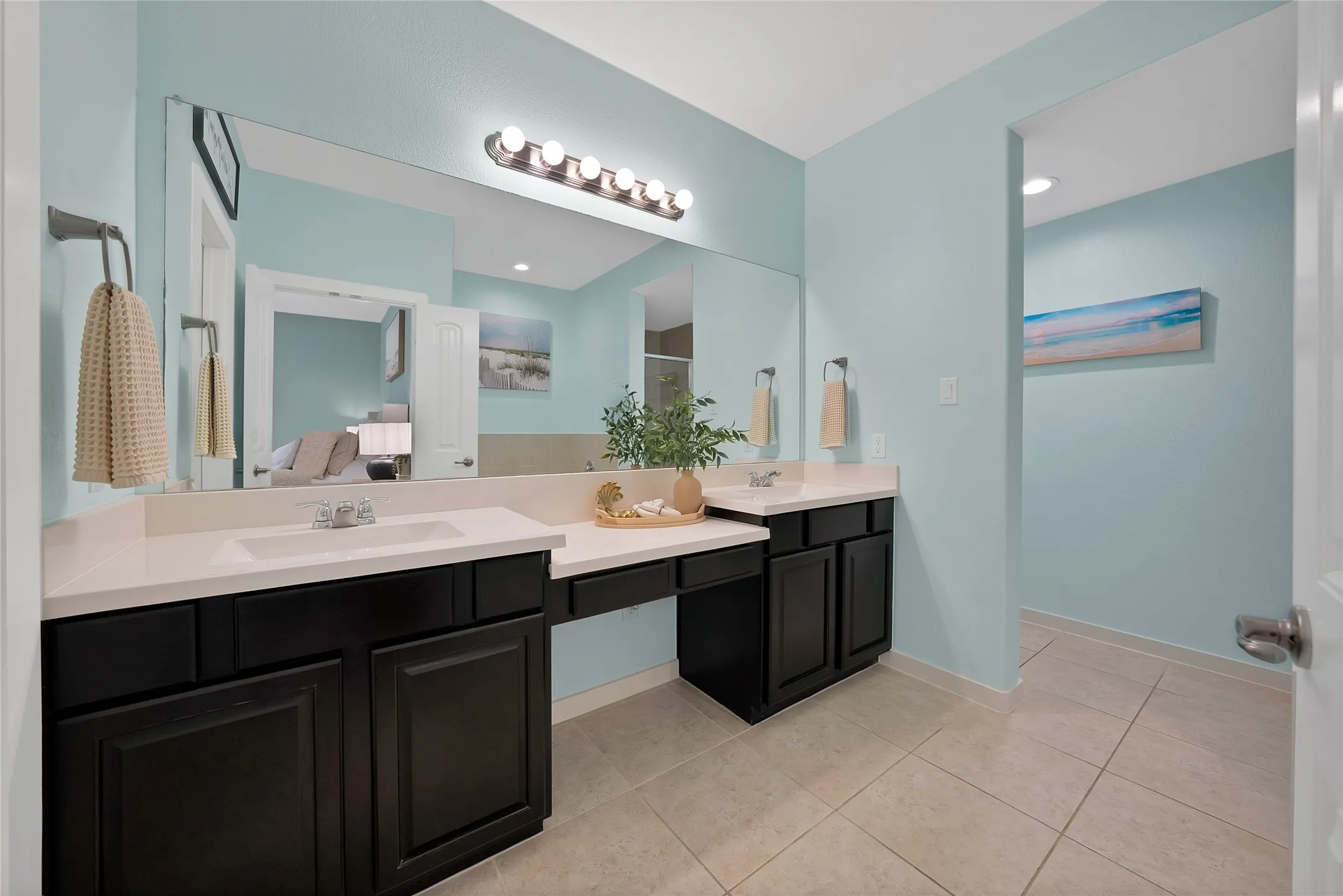 Dual vanity featuring dark wood-finish cabinetry, white countertops, and integrated sinks