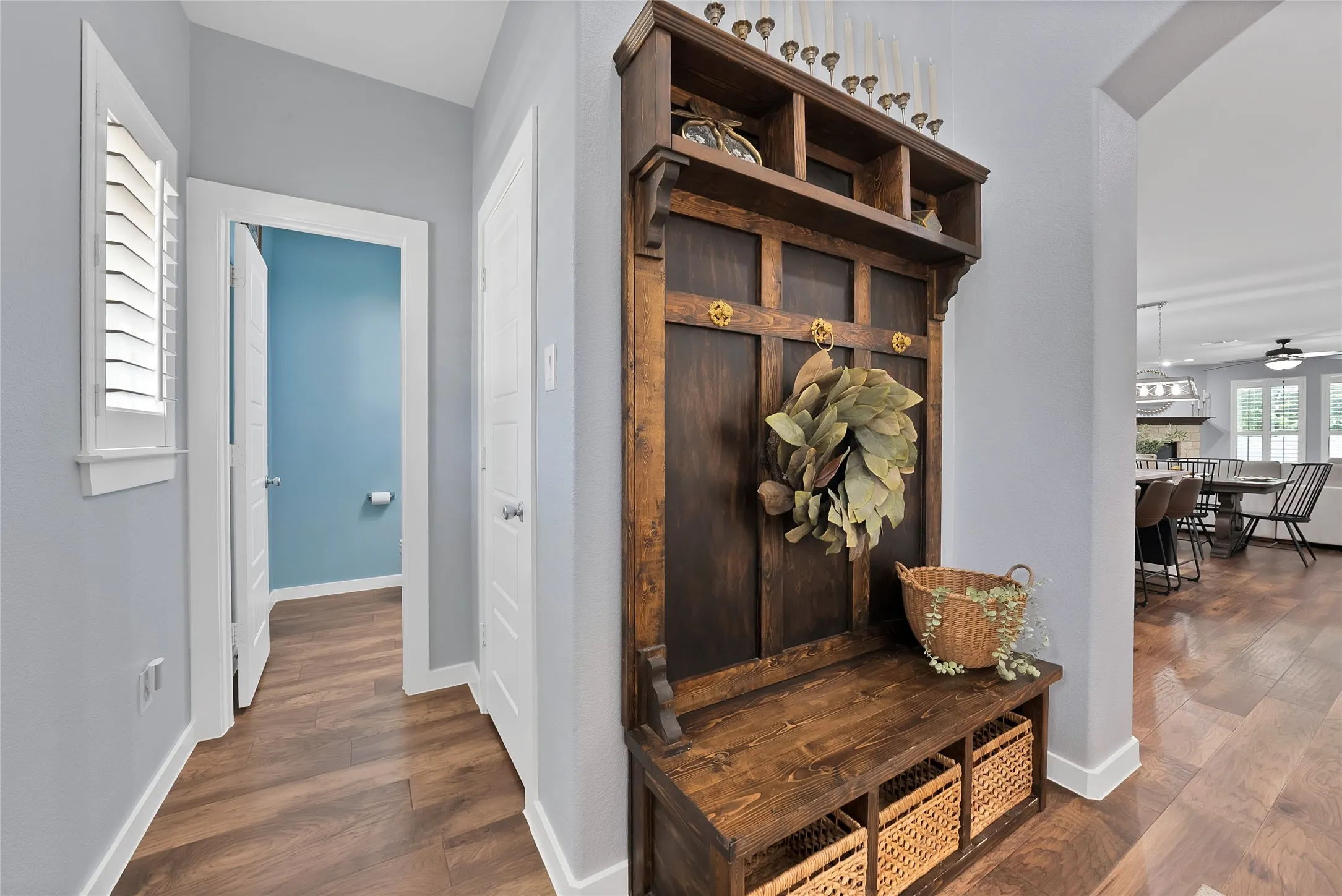 Rich wood-finish flooring throughout, featuring a built-in hall tree with integrated bench and storage