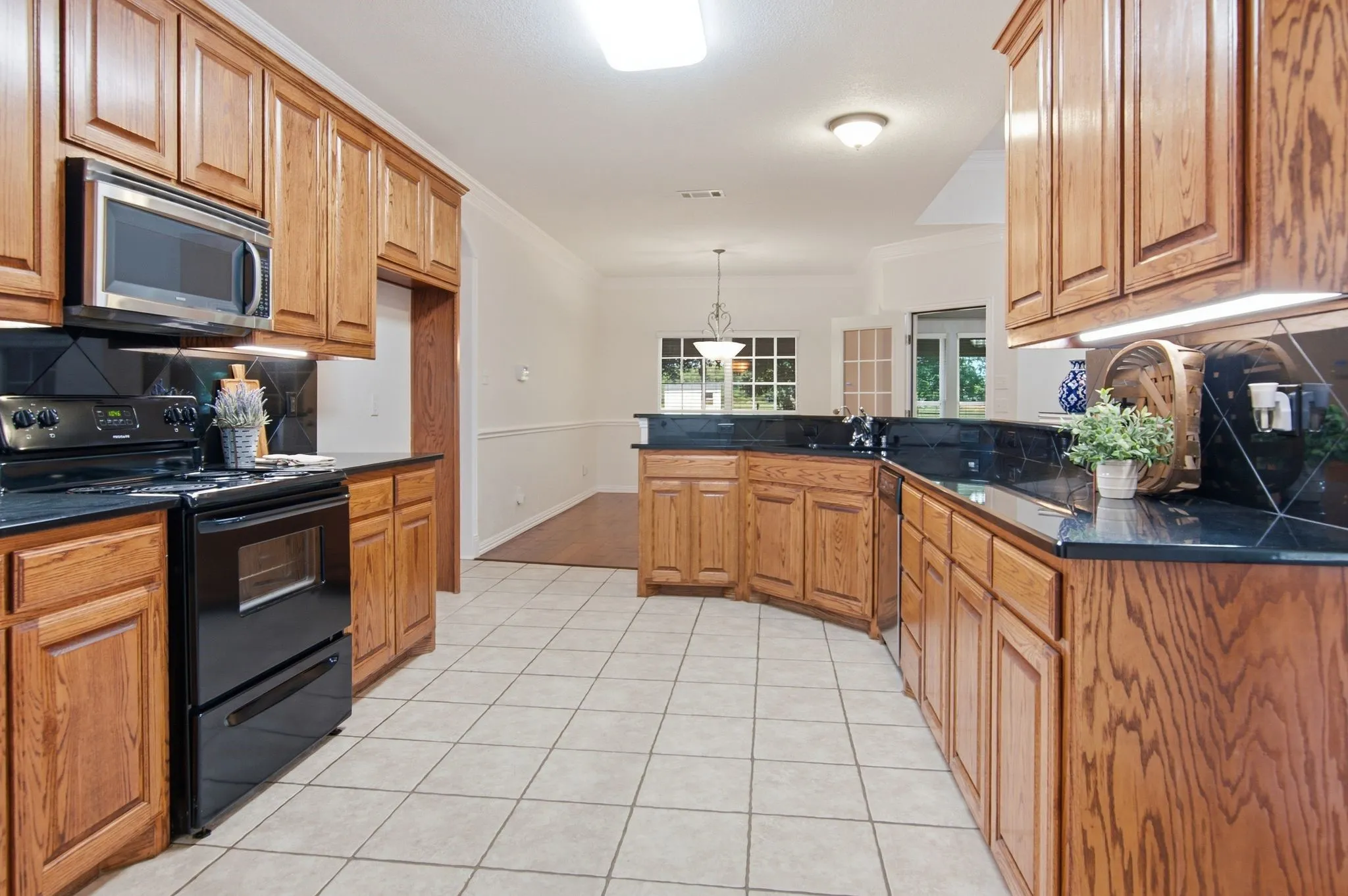 Large kitchen with rich wood cabinets, black granite counters & backsplash! Undercounter lighting!