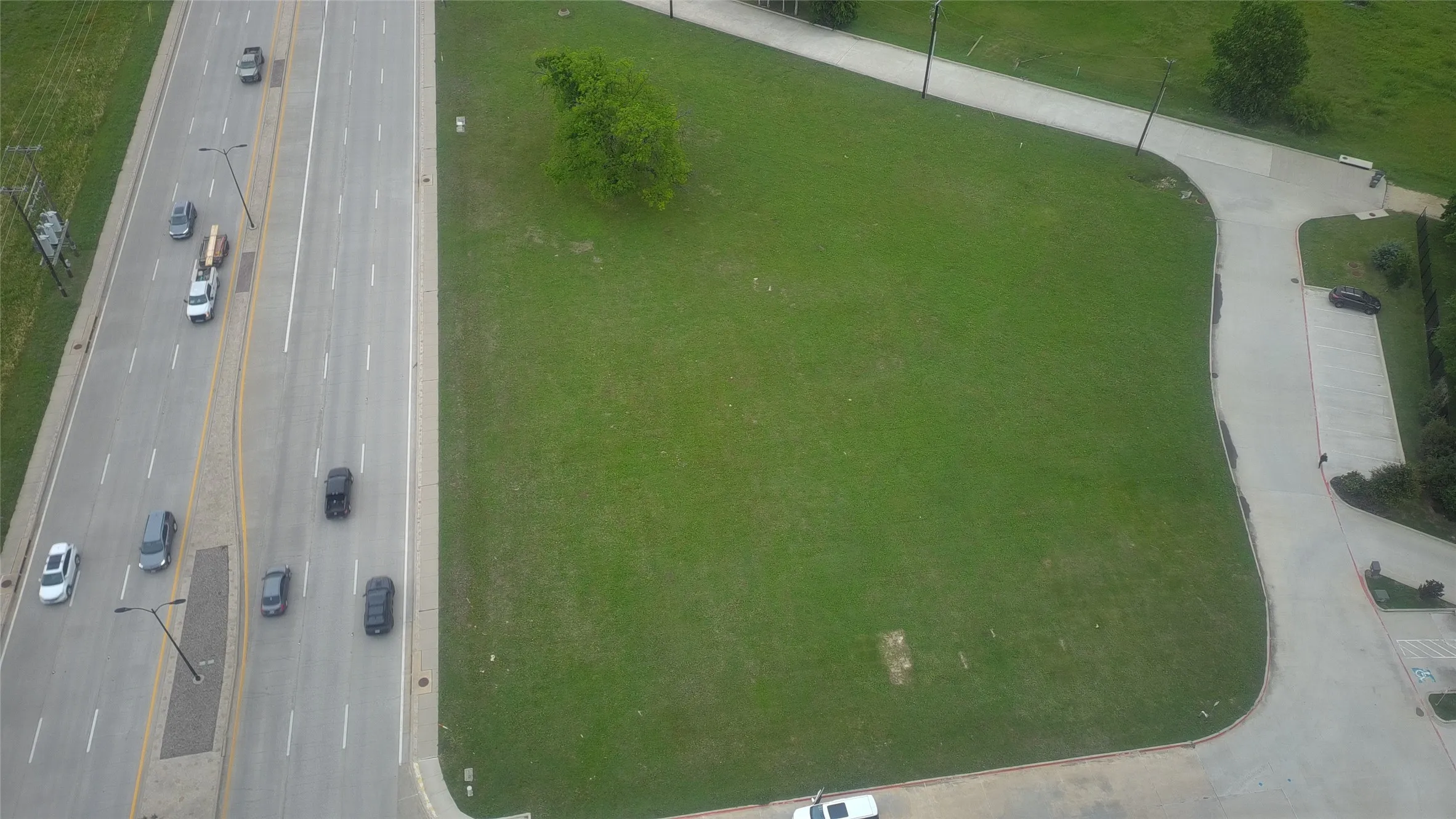 Expansive green space adjacent to a multi-lane road
