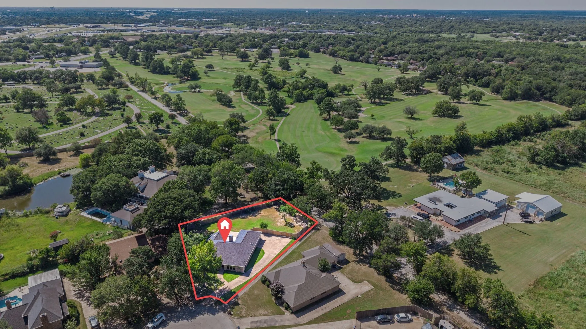 Aerial perspective showcasing a single-story residence with a red-outlined property boundary