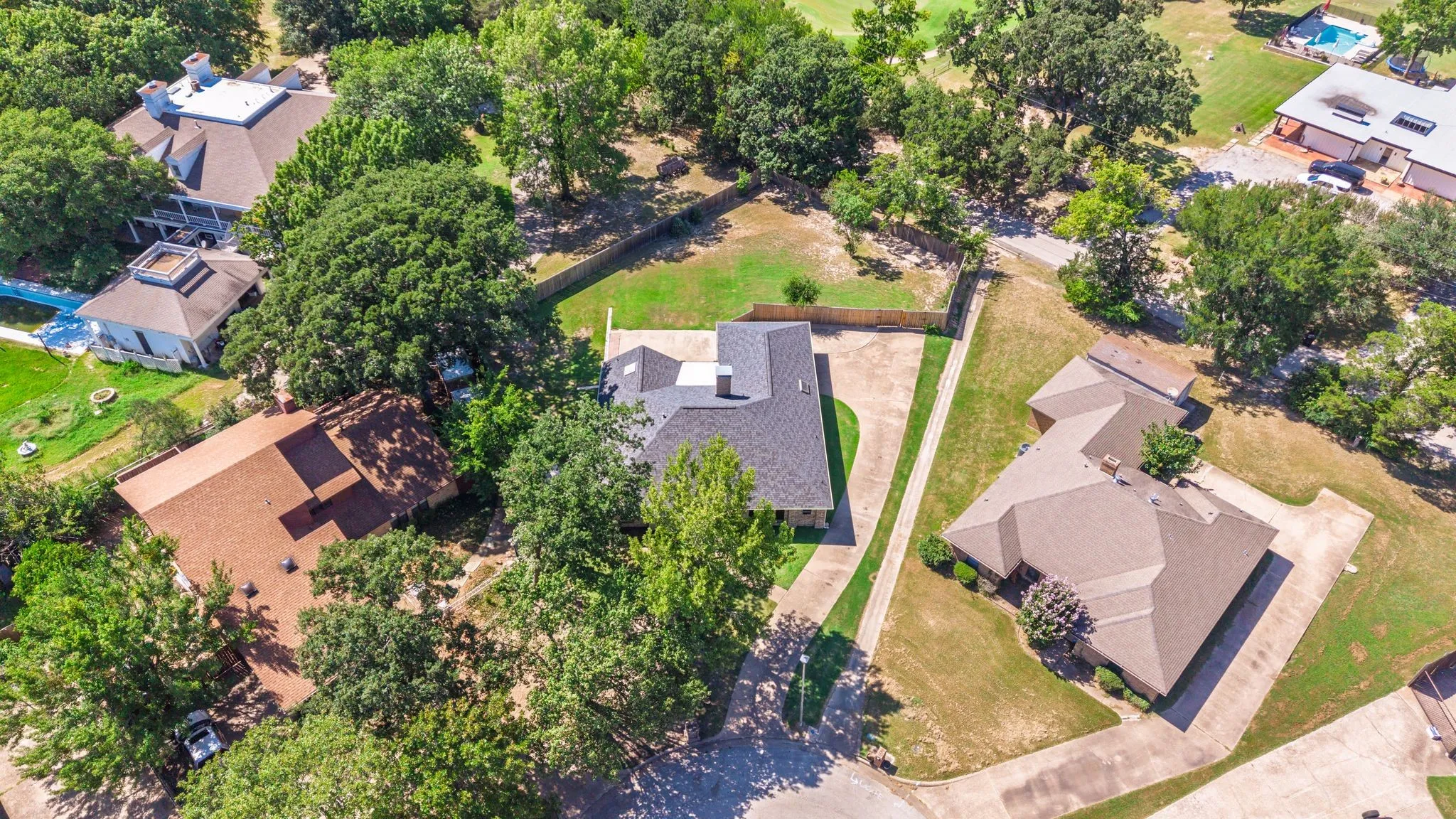 Spacious residential property with a dark shingle roof and a concrete driveway