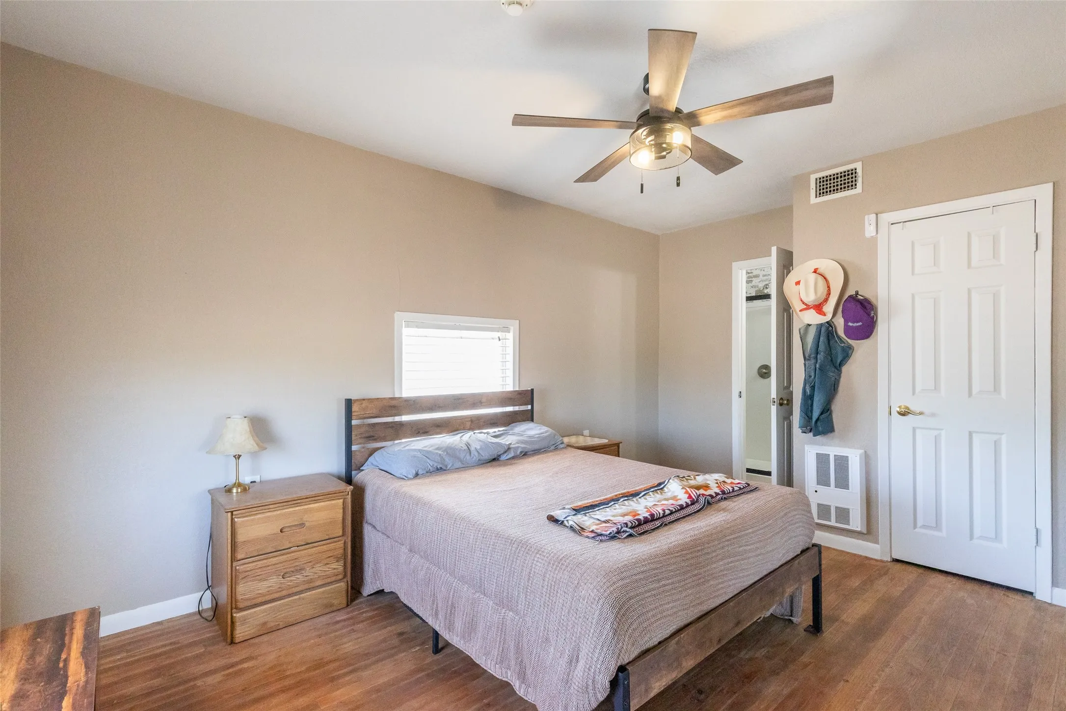 Room featuring wood-finish flooring and a ceiling fan with integrated lighting
