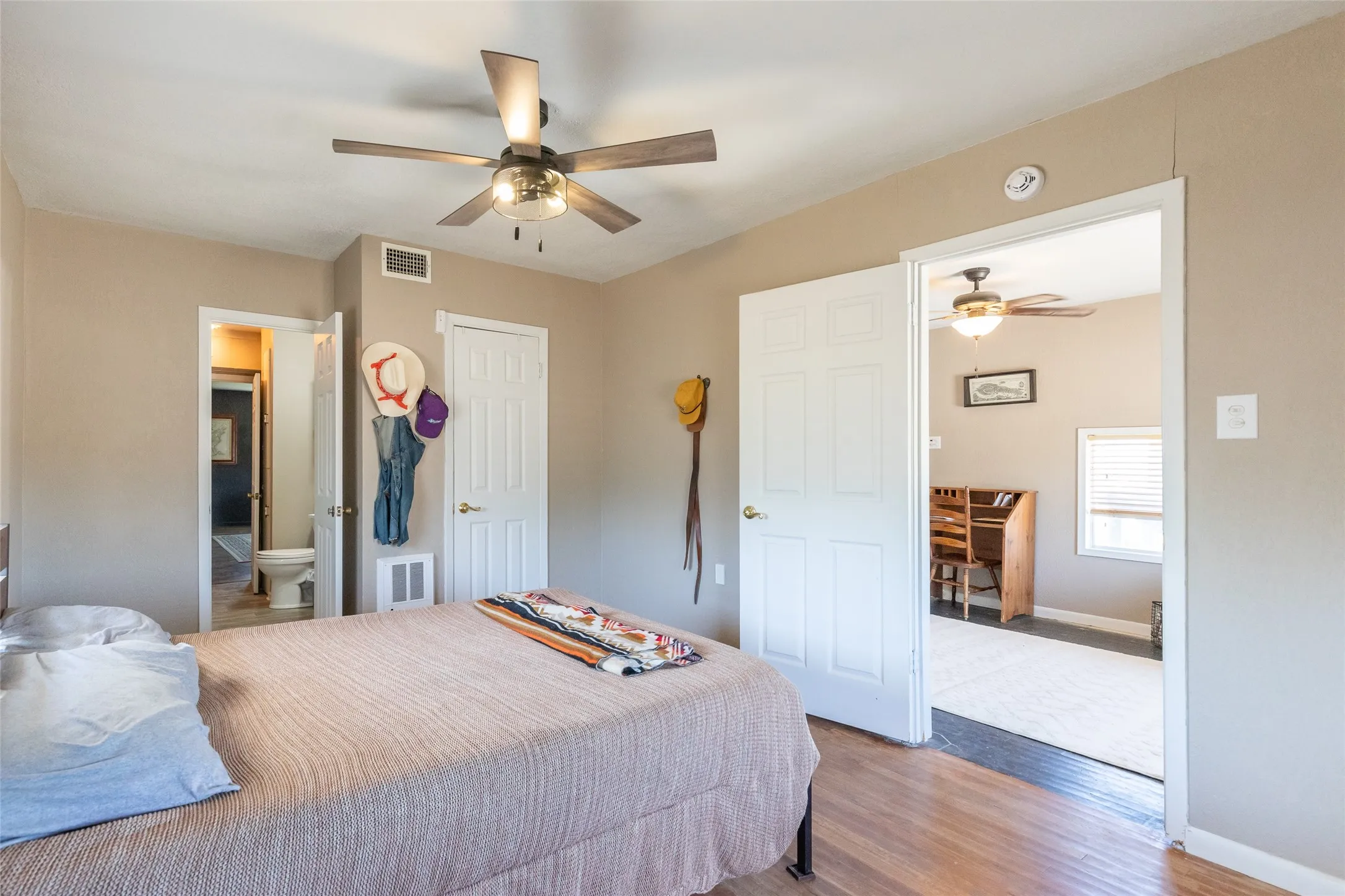 Bedroom featuring wood-finish flooring, a ceiling fan with integrated lighting, and neutral wall tones