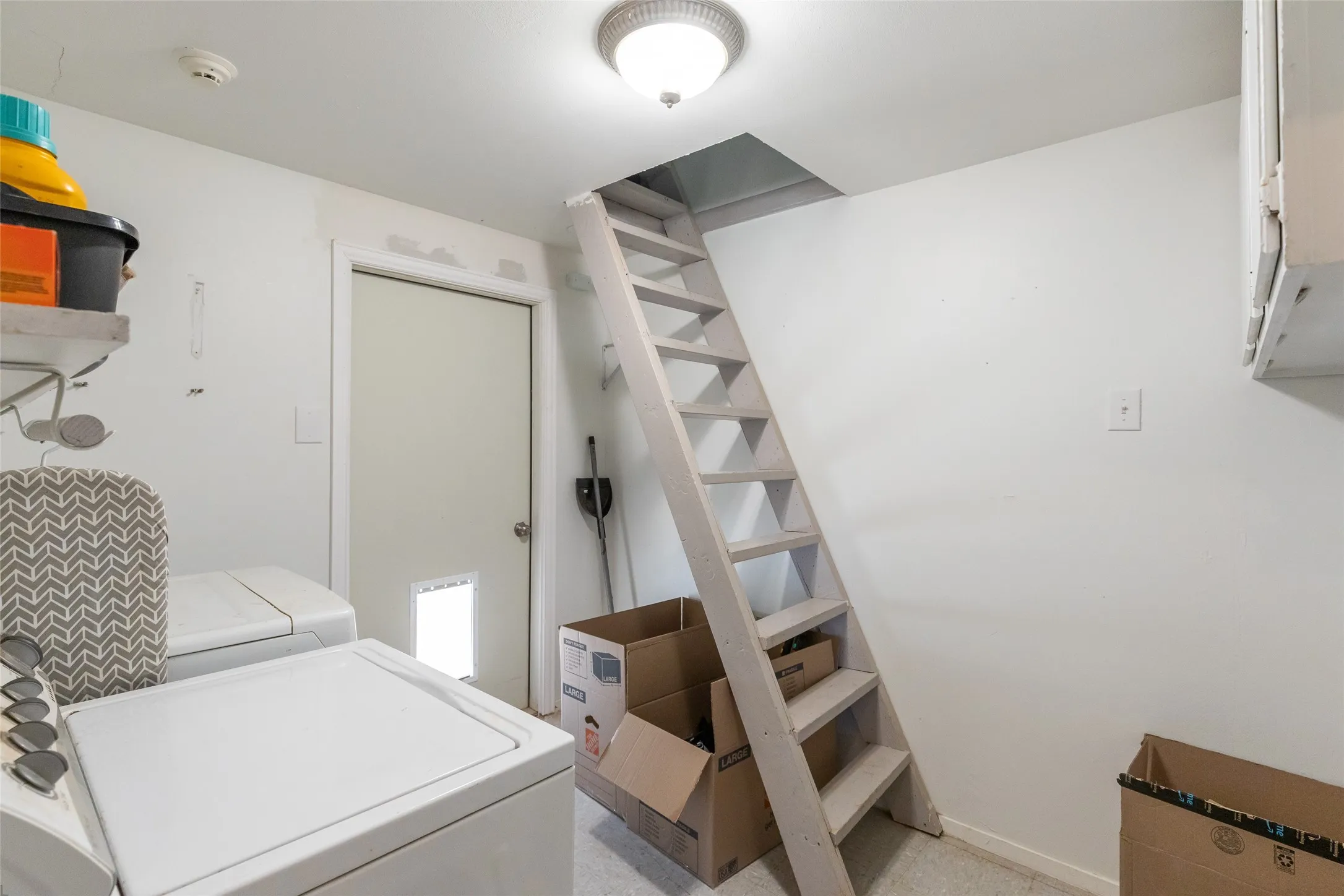 Laundry area with white walls and a ceiling-mounted light fixture