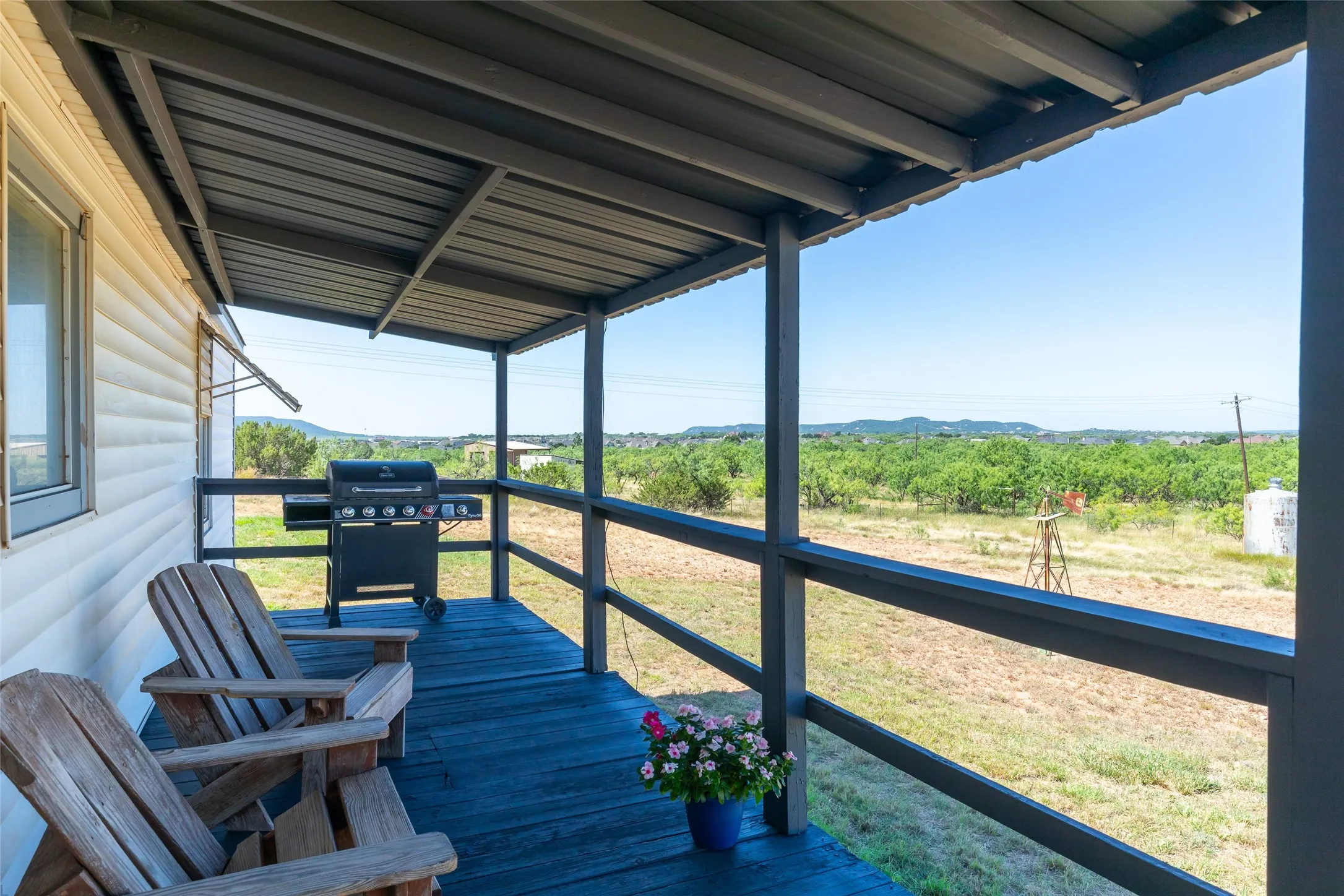 Covered porch with a metal roof and painted wood-finish decking