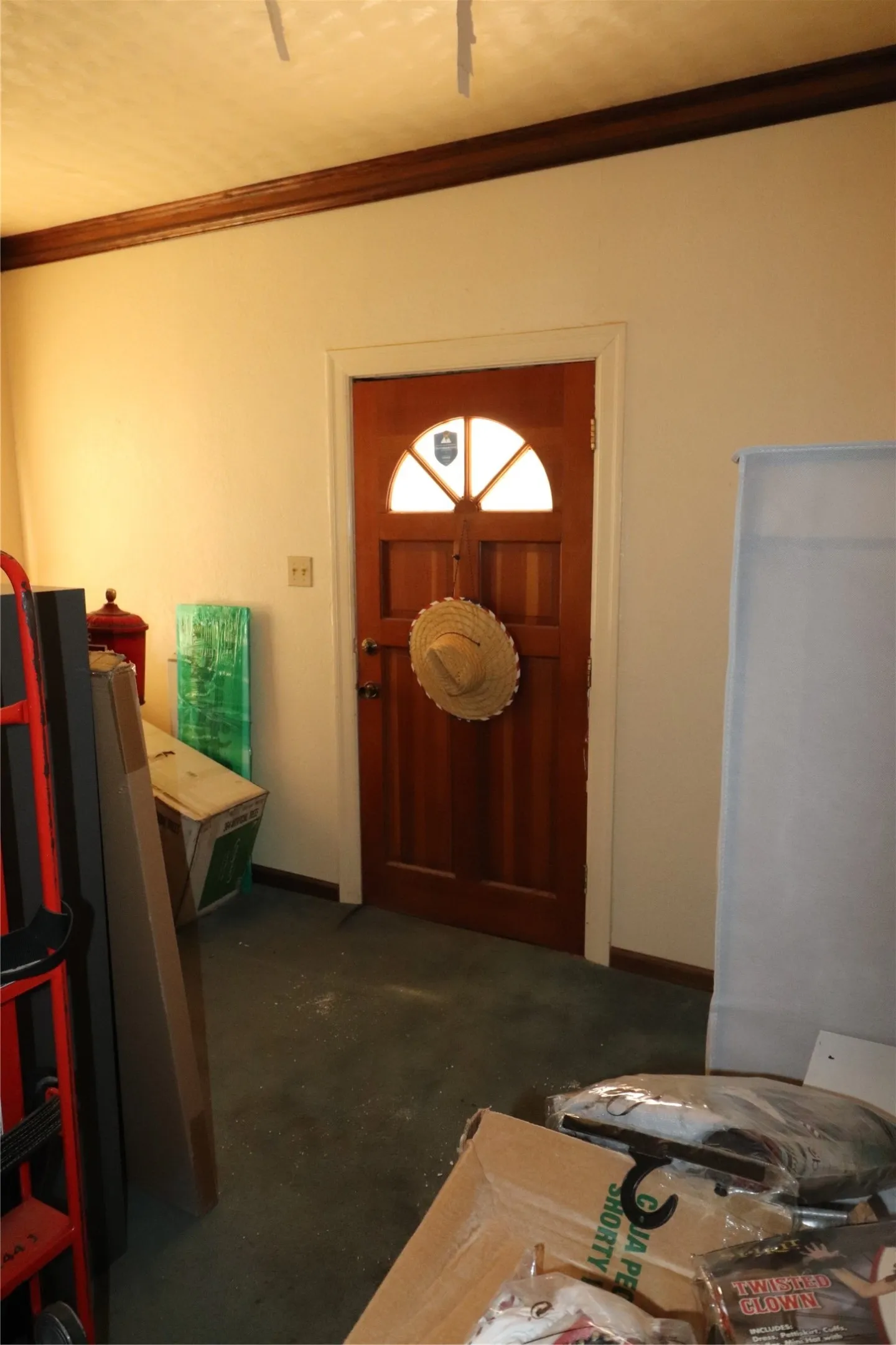 Wood-paneled door with arched glass insert, featuring white trim and a dark wood crown molding