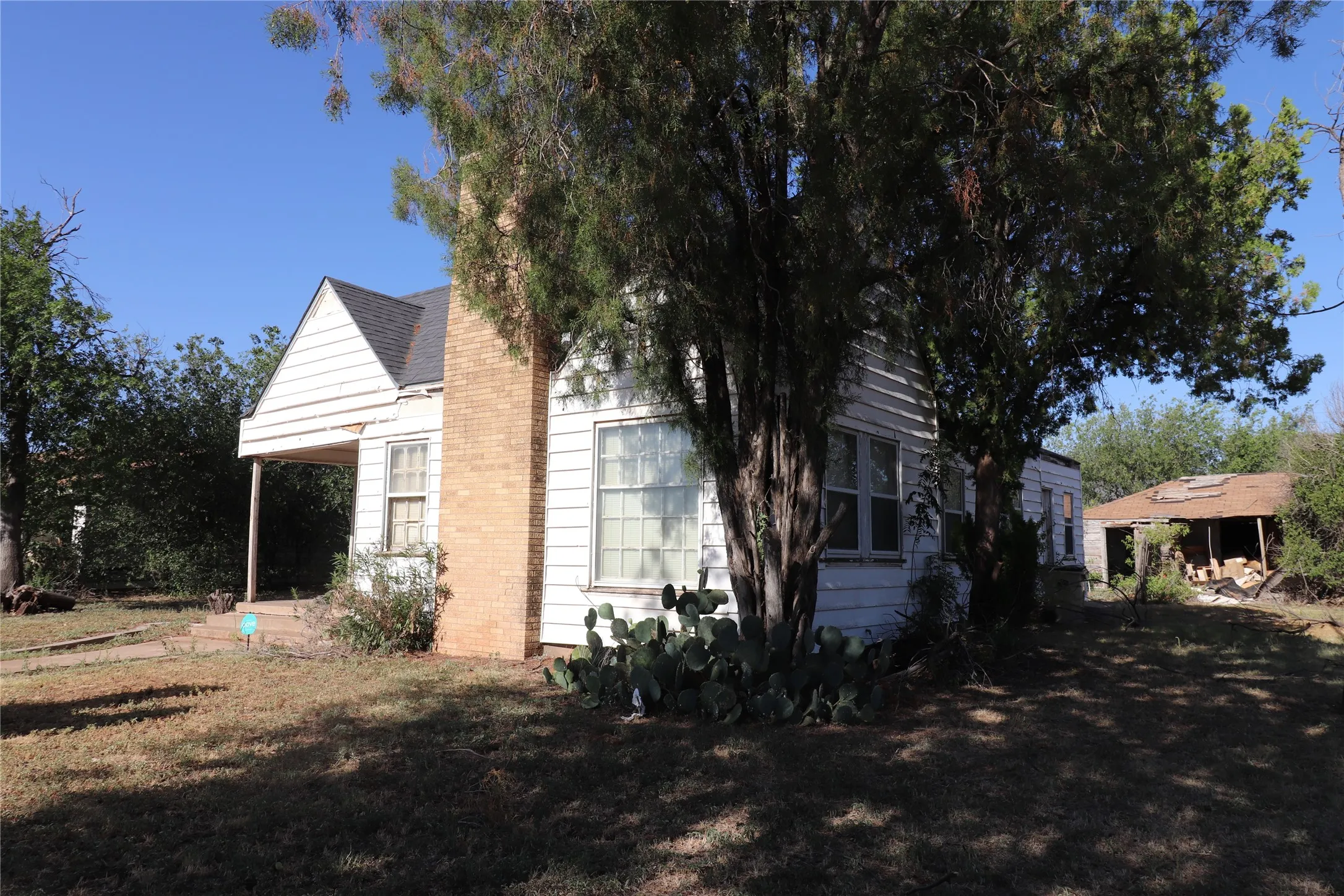 Exterior siding with a brick chimney and covered porch