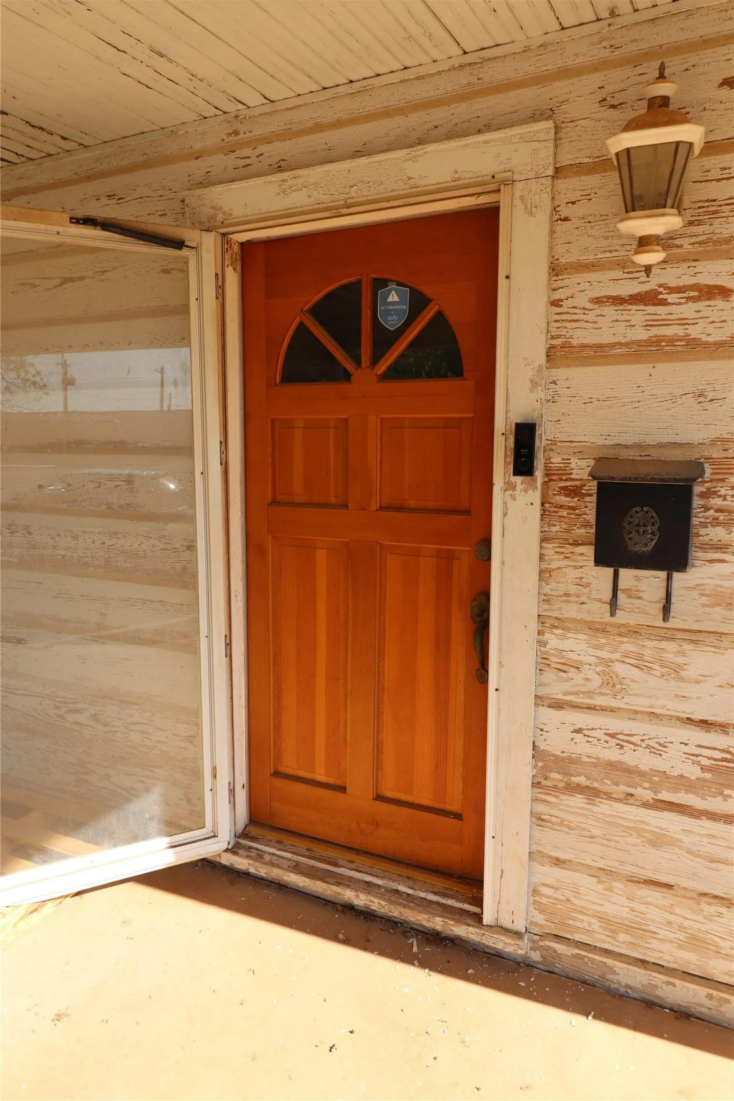 Wood-paneled entry door with an arched transom window