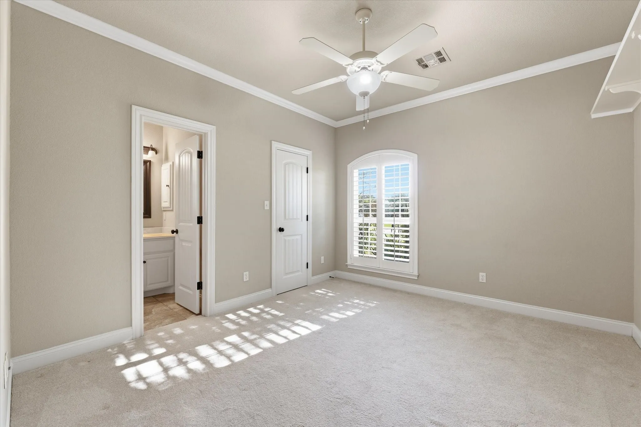 Carpeted room with crown molding and a ceiling fan