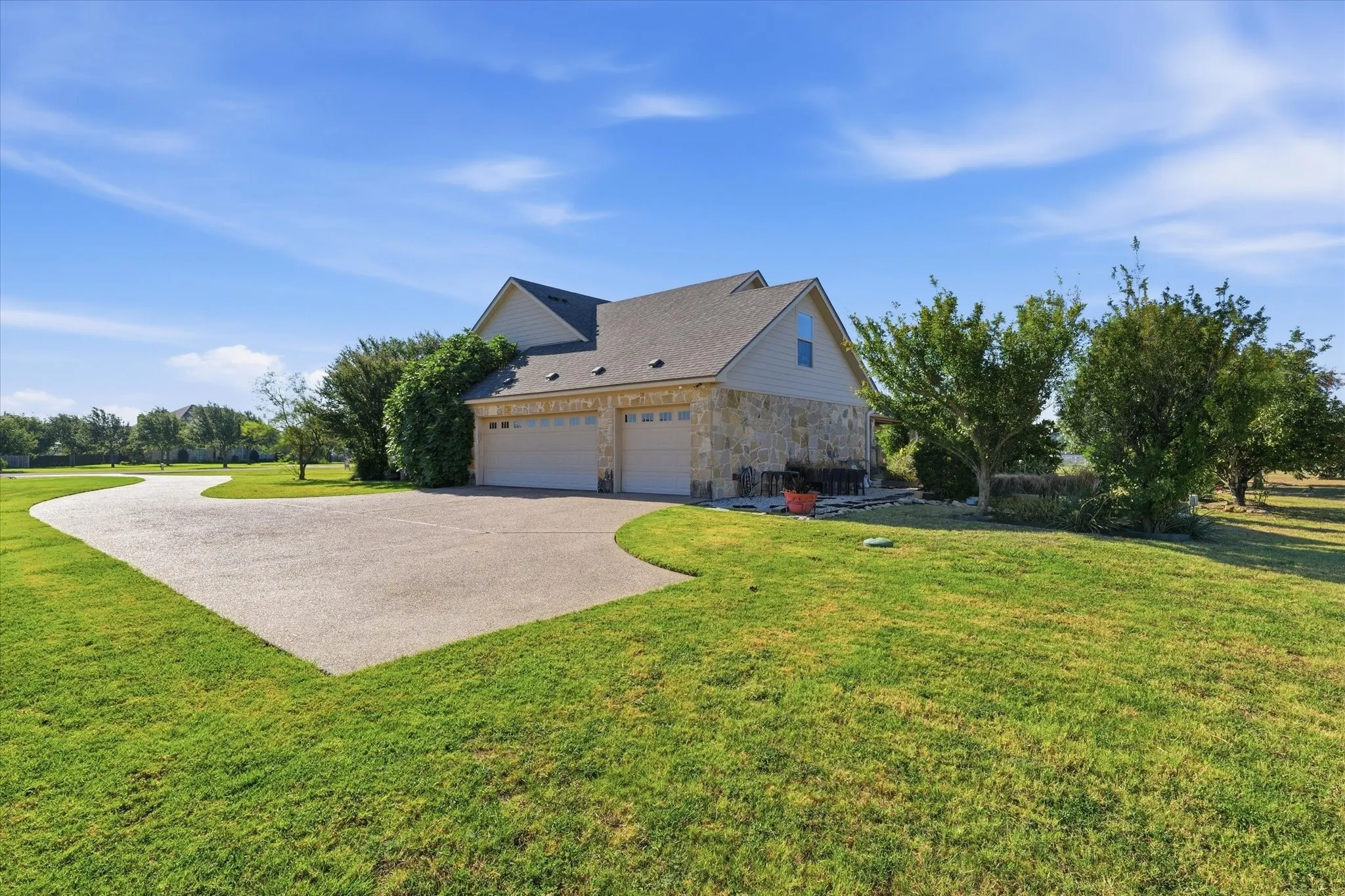 Two-car garage with stone and siding exterior