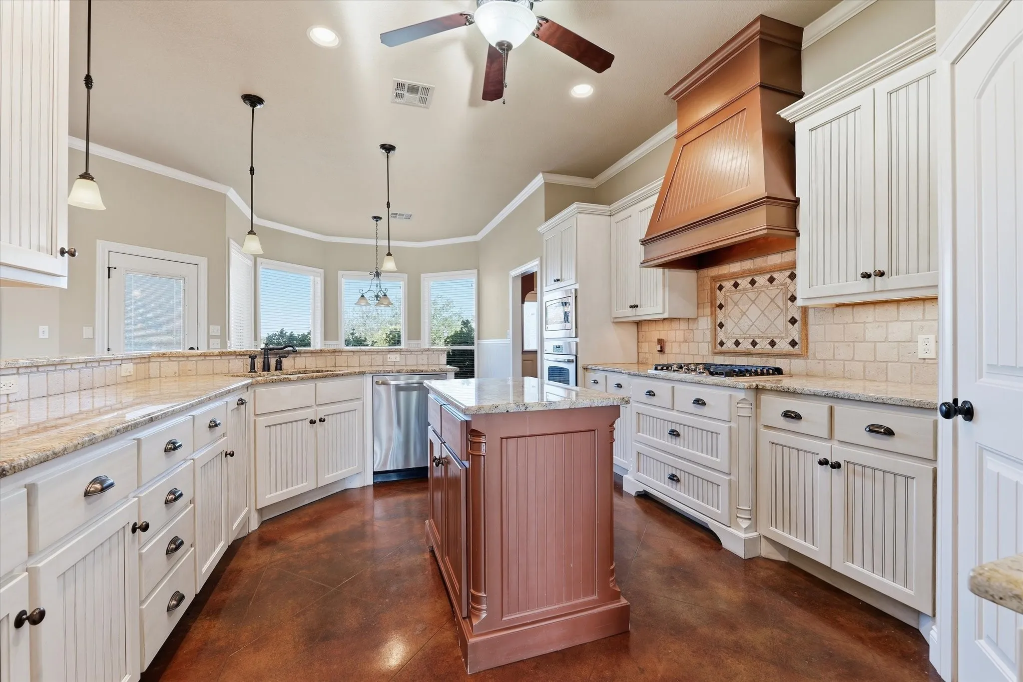 Spacious kitchen featuring white cabinetry, a central island, and wood-finish flooring